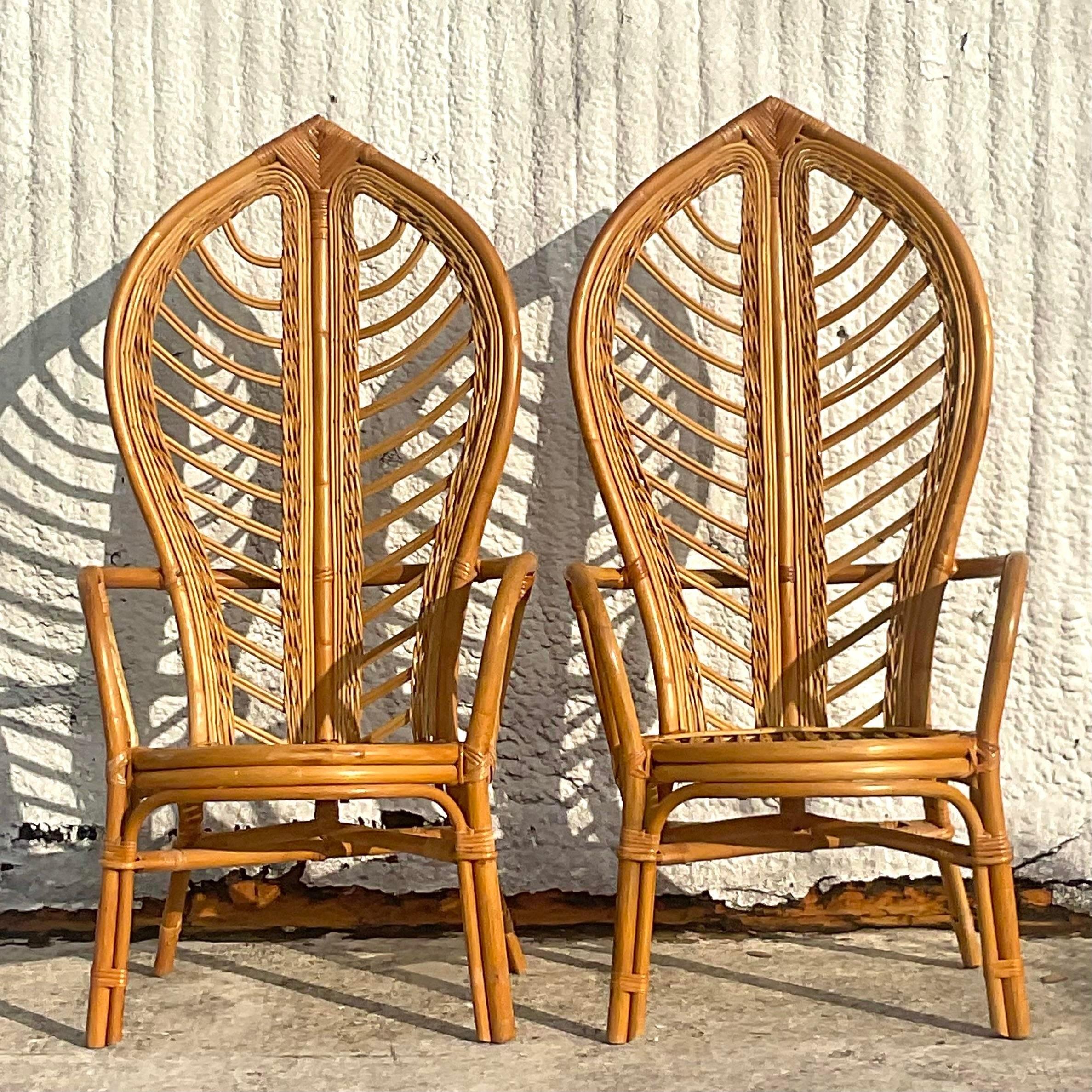 A stunning pair of vintage Coastal lounge chairs. Thr iconic leaf back design in classic bent rattan. Perfect for a flash of drama at the ends of your dining table or either side of your credenza. Acquired from a Palm Beach estate.
