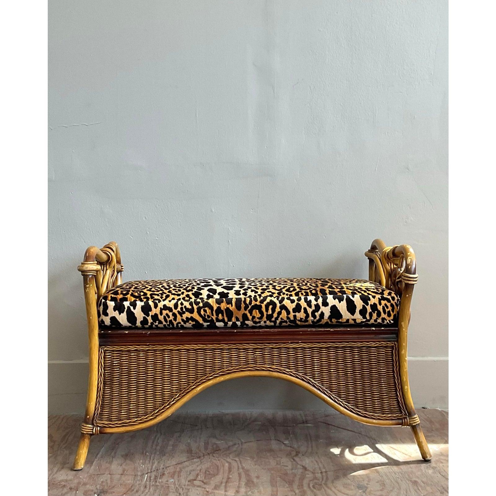 Embrace a touch of the exotic with this stunning vintage bent rattan bench, a perfect marriage of coastal ease and Hollywood Regency glamour. The expertly crafted frame showcases the natural beauty of rattan, with sculptural, rounded arms and a