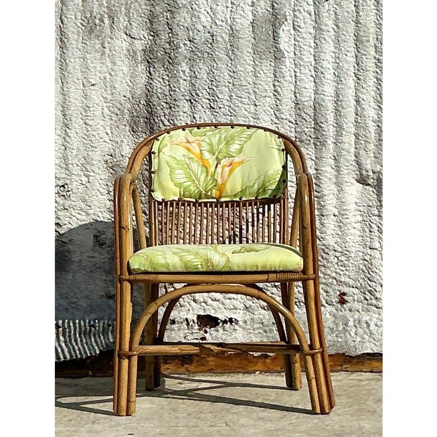 Add a tropical touch to your interior with this stunning vintage coastal bent rattan lounge chair. Featuring a beautifully curved rattan frame and upholstered cushions with vibrant botanical prints, this chair effortlessly blends comfort and natural