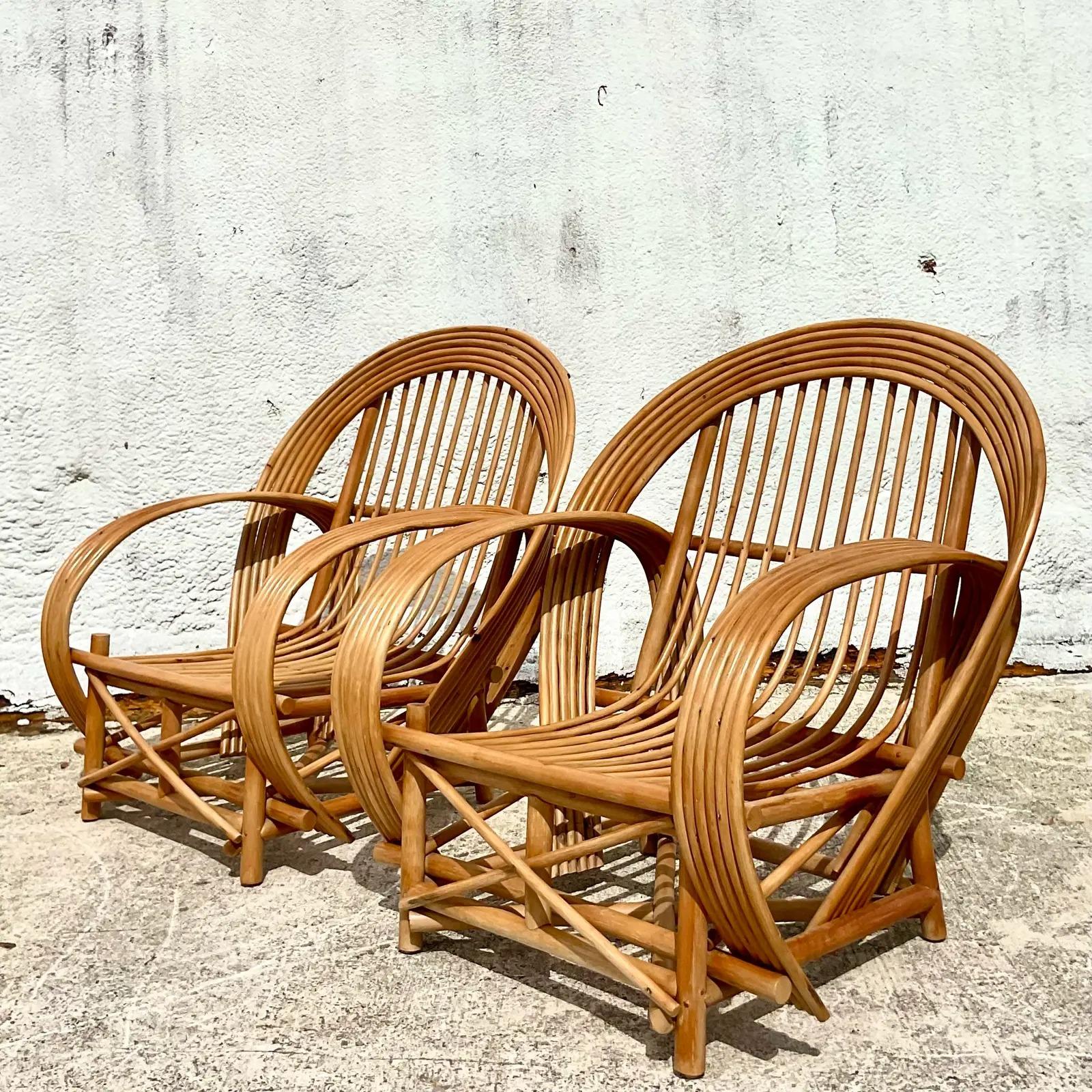 Fantastic pair of vintage Coastal lounge chairs. Beautiful bent rattan in a sexy high back shape. Perfect indoors or outside in a covered area. Acquired from a Palm Beach estate. 