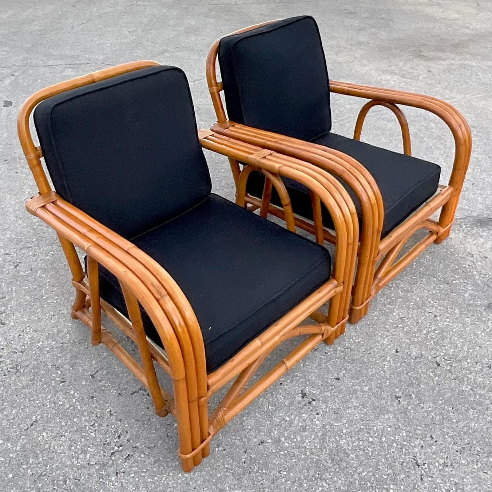 A fabulous pair of vintage Coastal lounge chairs. Beautiful bent rattan in a chic and clean design. Black duck cloth upholstery. Matching sofa also available. Acquired from a Palm Beach estate.
