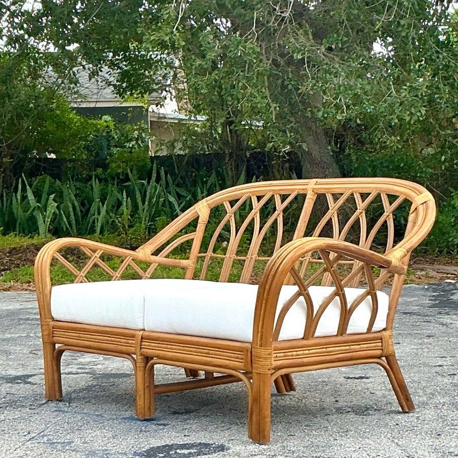 Dieser küstennahe, gebogene Rattansessel im Vintage-Stil bietet eine perfekte Mischung aus Charme und Haltbarkeit. Mit seinem anmutig geschwungenen Rahmen und der natürlichen Rattan-Konstruktion strahlt er eine luftige, strandnahe Ästhetik aus.