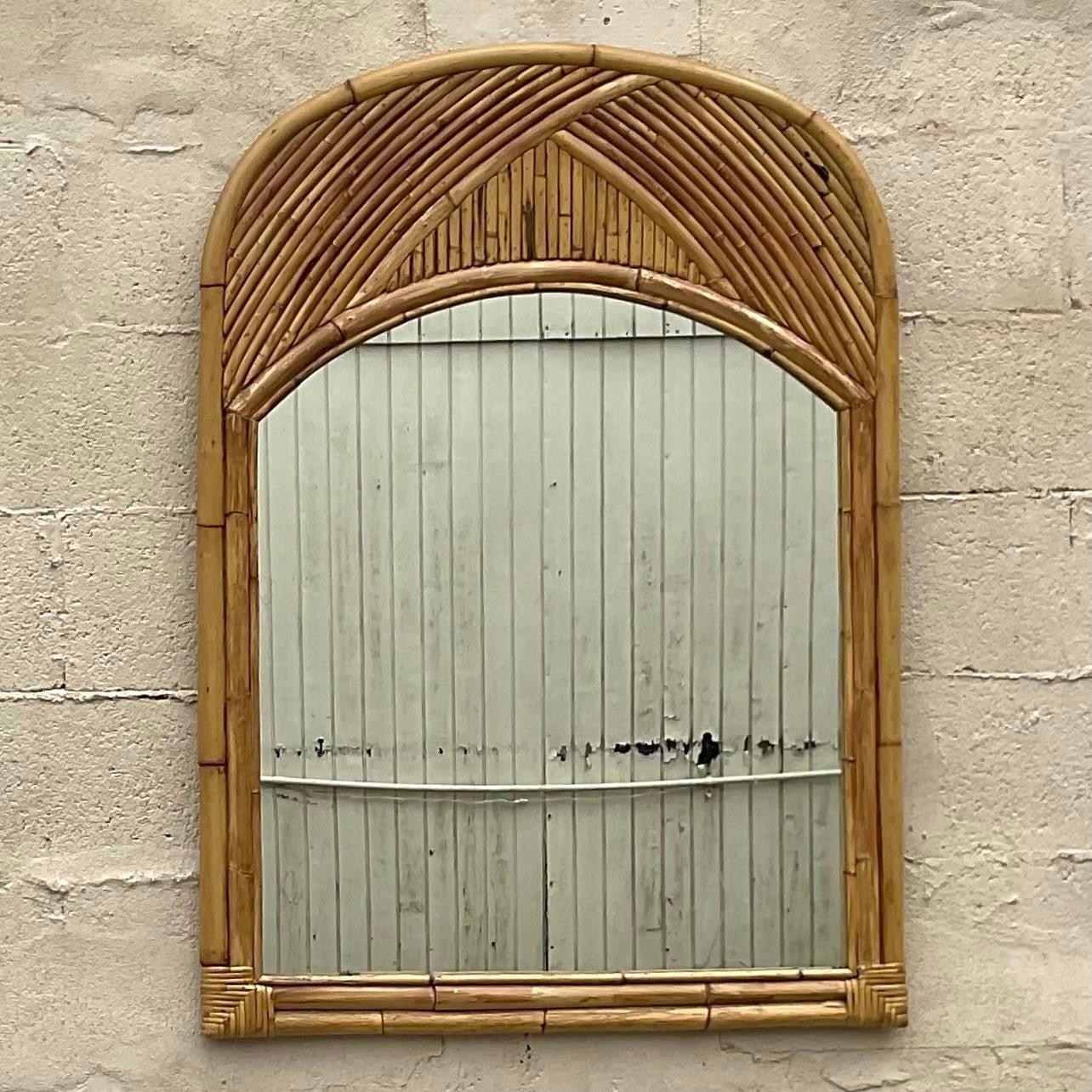 A fabulous vintage Costal wall mirror. Chic bent rattan is an arching design. Acquired from a Palm Beach estate.