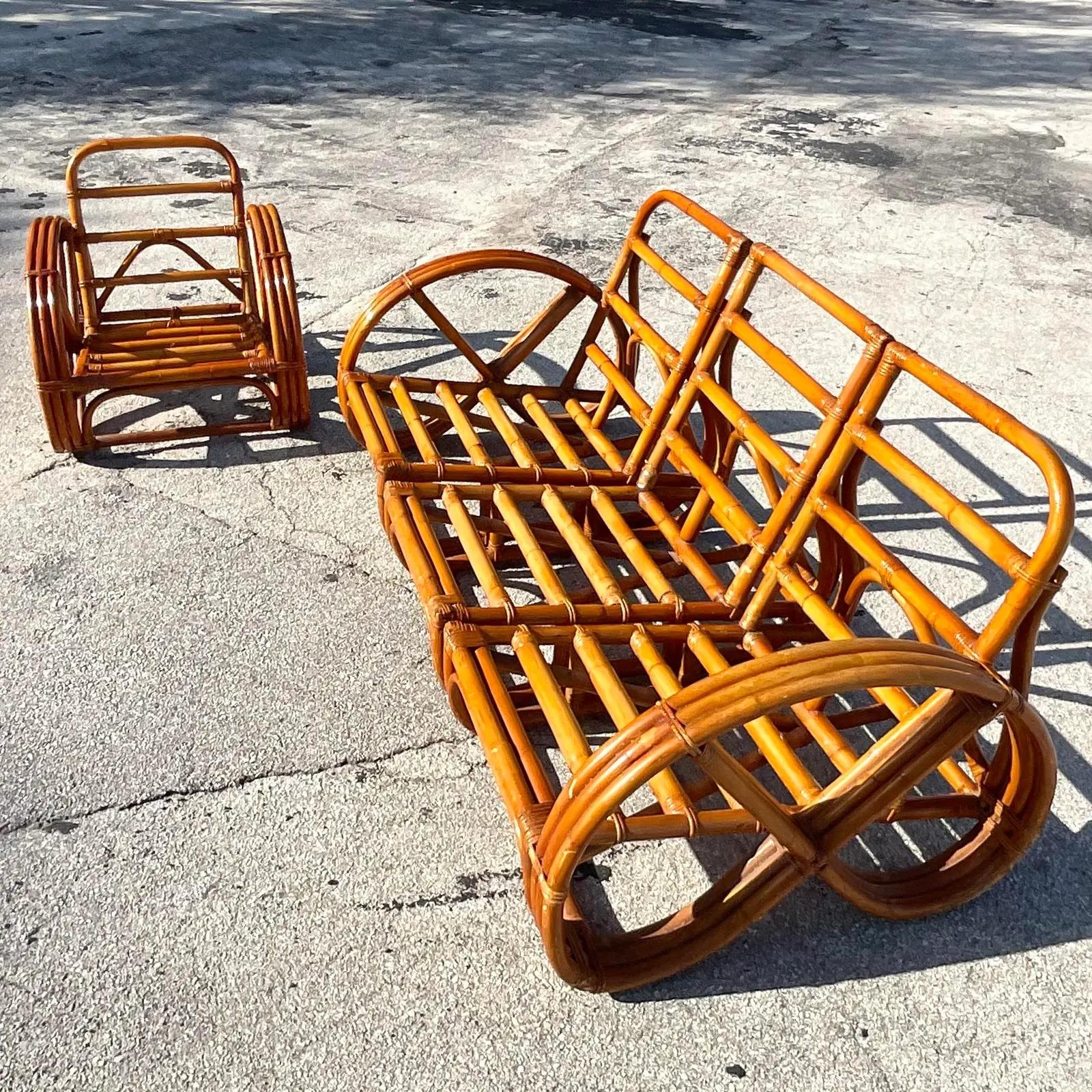 A fabulous vintage Coastal sofa and chair. Beautiful bent rattan in the classic pencil shape. Done in the manner of Paul Frankl. Full set of cushions included. Acquired from a Palm Beach estate.

Chair dimensions - 26.5x24x26.5x10.5.