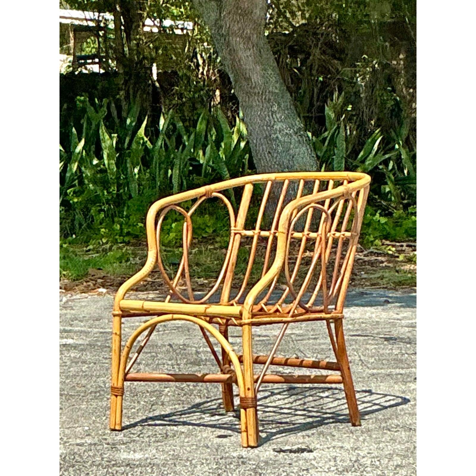 Add a breezy, coastal charm to your space with this vintage bent rattan tub chair. Crafted with a sculptural open-weave back and elegantly curved arms, this chair is a striking example of mid-century tropical style. Its handwoven frame showcases