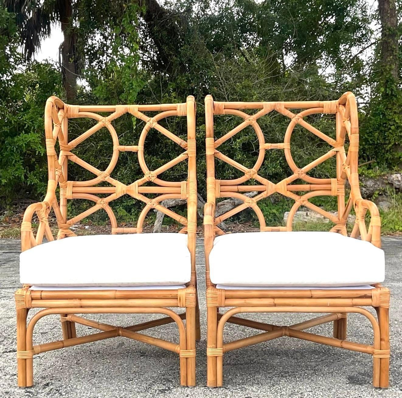 Experience coastal comfort with our Vintage Coastal Bent Rattan Wingback Chairs - A Pair. These elegant wingback chairs feature bent rattan frames, blending classic wingback design with coastal charm. A perfect duo that adds a touch of American