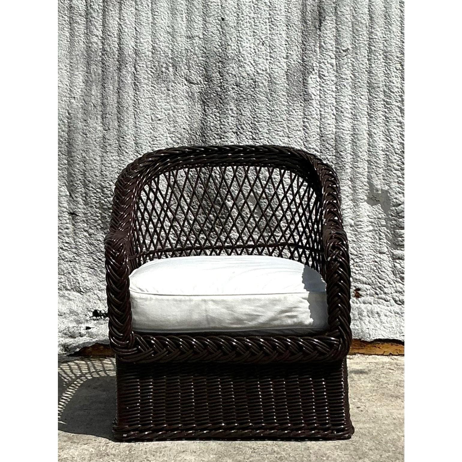 Realizzata dagli iconici Bielecky Brothers, questa poltrona vintage in rattan costiero è caratterizzata da un intreccio magistrale e da un comfort lussuoso. La struttura in rattan riccamente intrecciata è intrecciata a mano con precisione e presenta