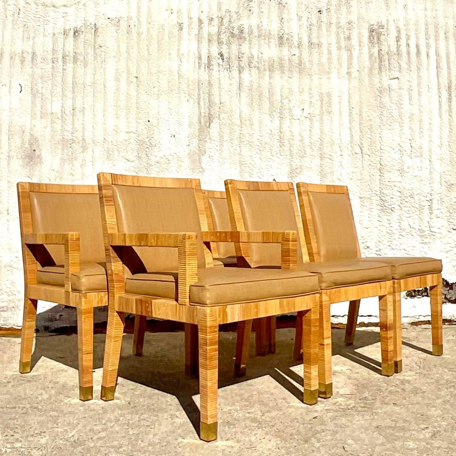 A spectacular set of vintage Coastal dining chairs. Made by the iconic Bielecky Brothers and tagged twice on the bottom. Chic wrapped rattan with brass caps on each legs. Faux leather seats in a tonal lizard design. Acquired from a Palm Beach