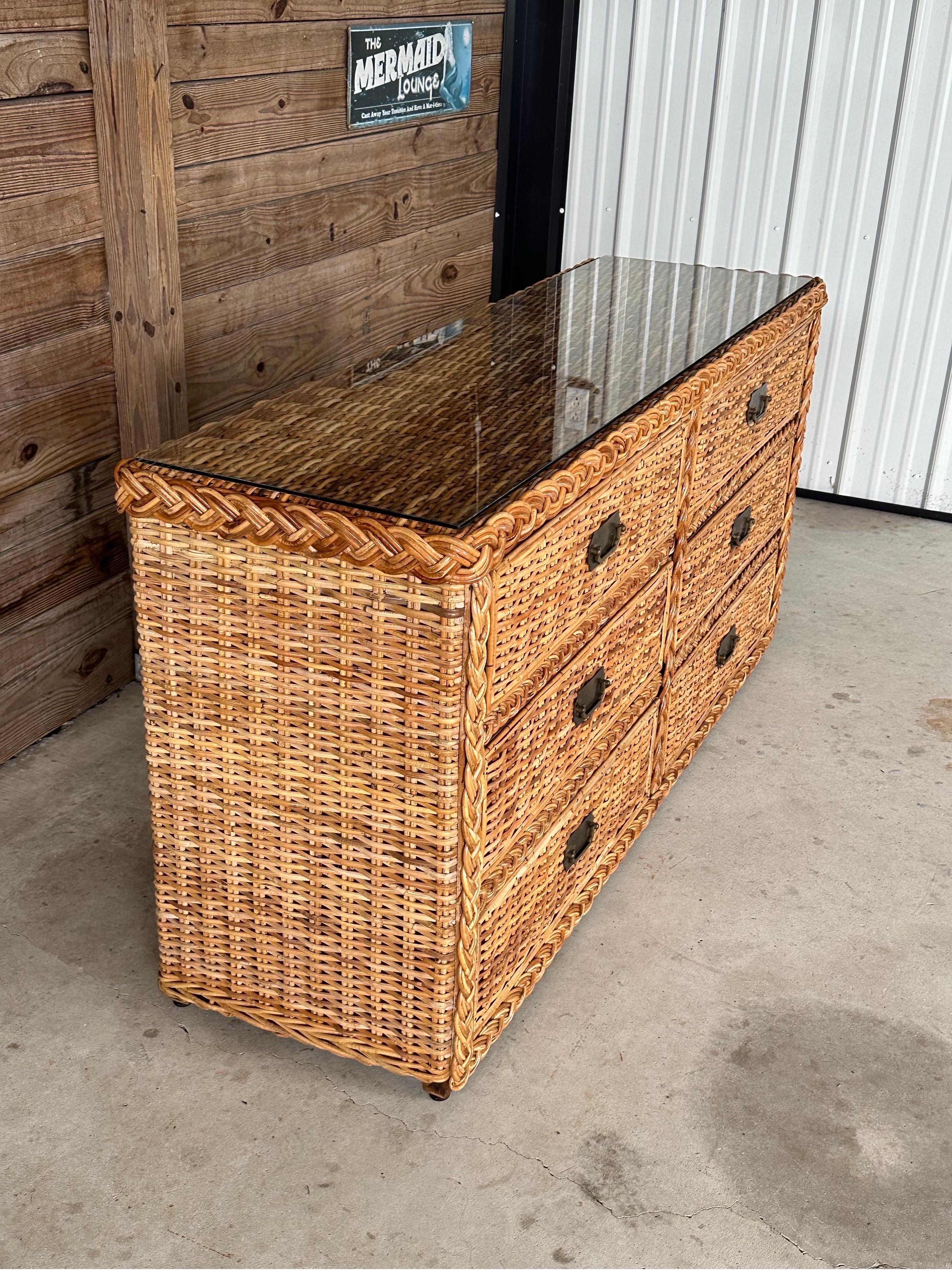 Questo splendido comò vintage a sei cassetti in rattan a treccia grande emana un'eleganza e un fascino senza tempo. Il comò presenta un nuovo piano in vetro che aggiunge un tocco di modernità pur mantenendo il suo fascino classico. L'originale