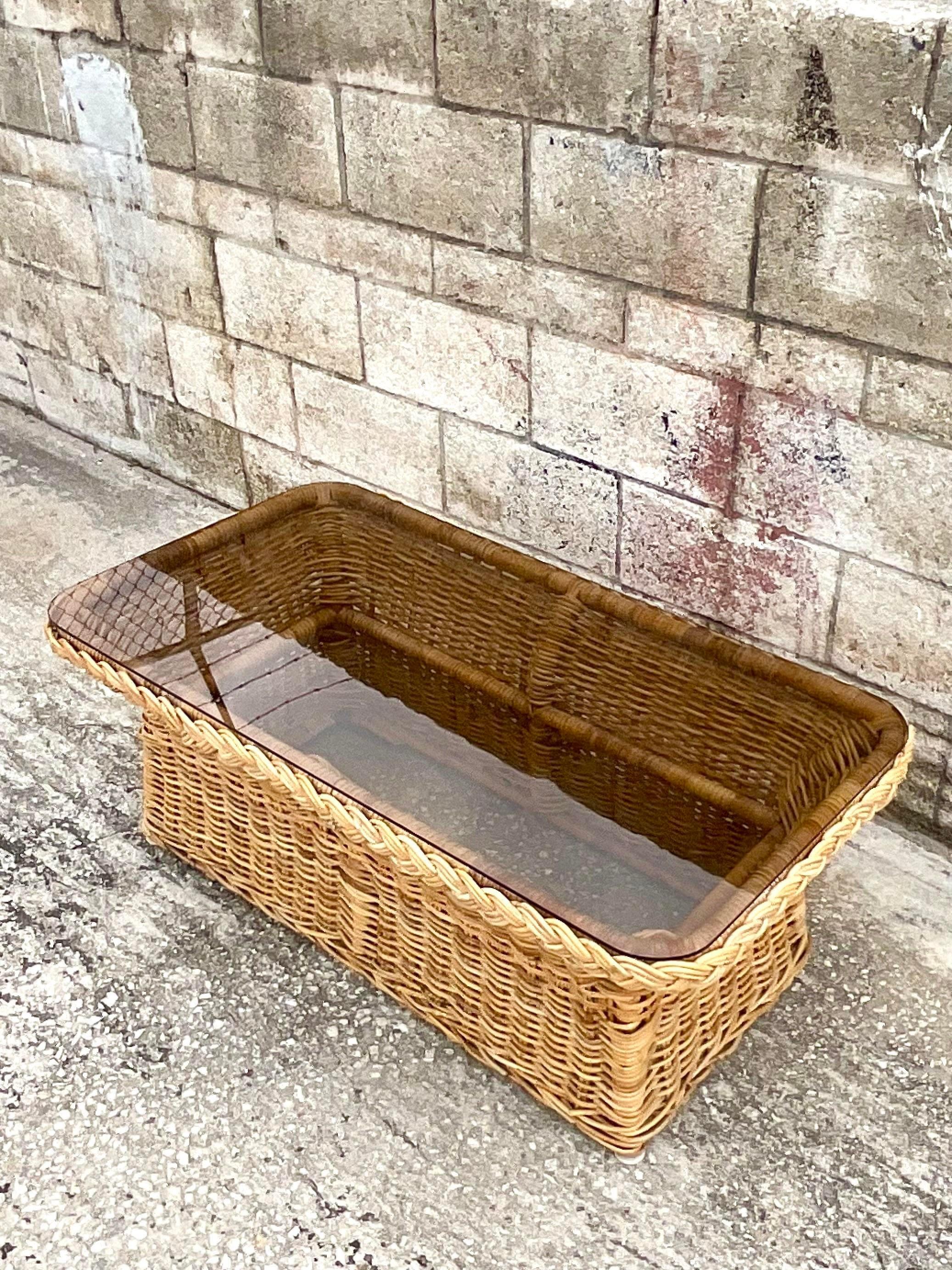 Fabulous vintage Coastal coffee table. Beautiful braided rattan trim with a chic smoke glass top. Perfect in so many different rooms. Indoors or outside. You decide! Acquired from a Miami estate.