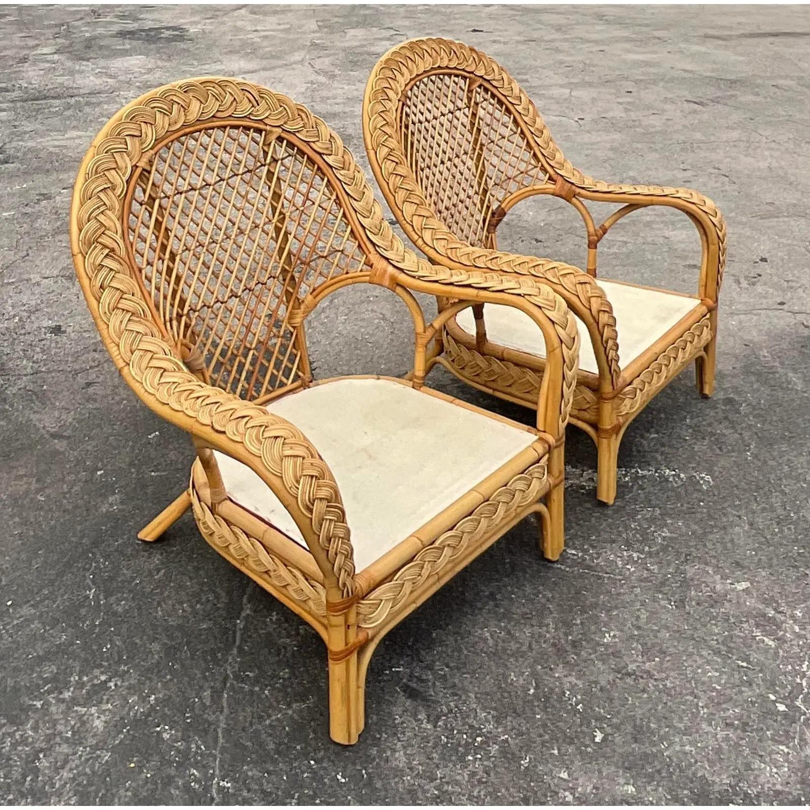Fabulous pair of vintage Coastal lounge chairs. Gorgeous braided rattan with a high paddle back. Matching sofa and loveseat also available. Acquired from a Palm Beach estate. Cushions included.