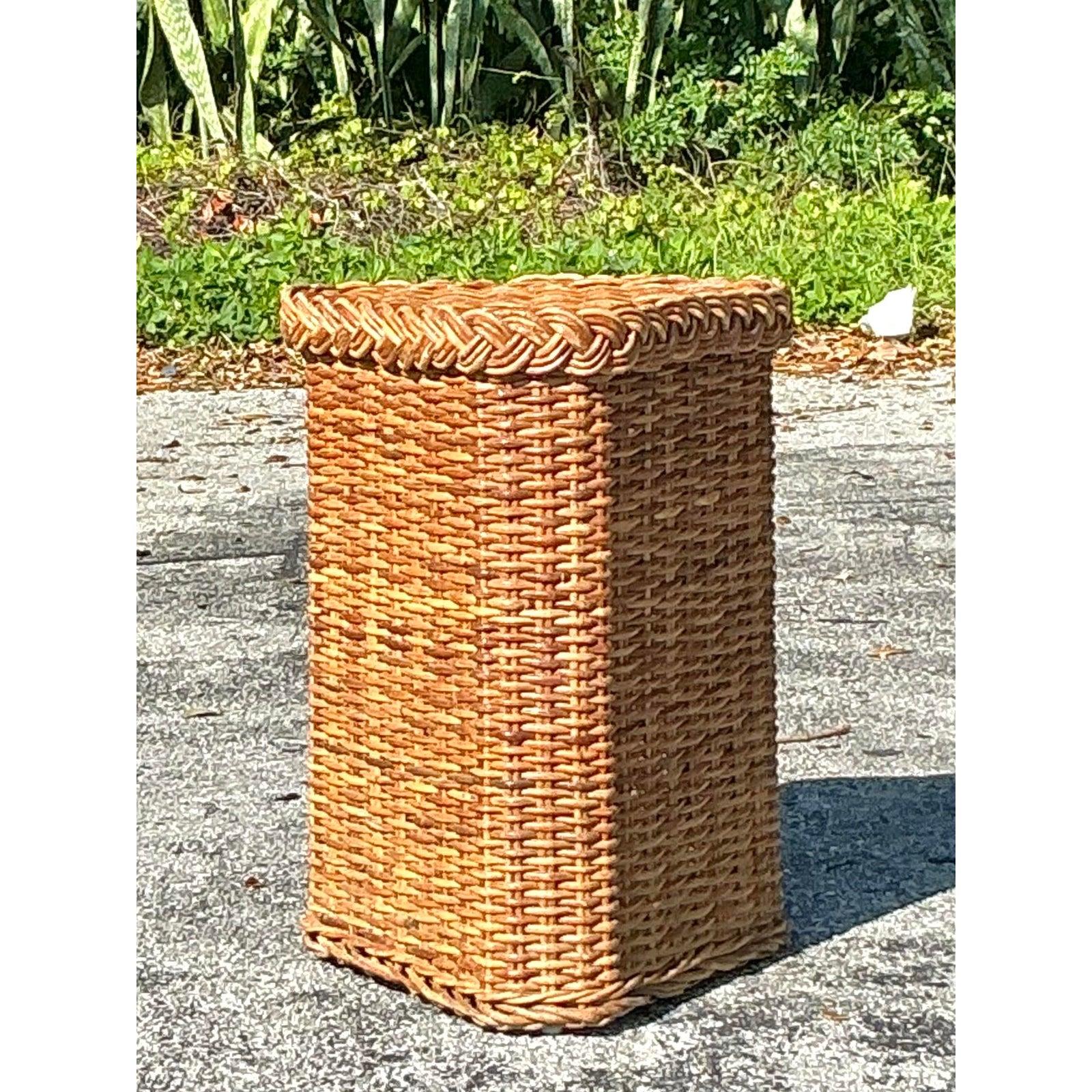 Bringen Sie einen Hauch von natürlicher Eleganz in Ihren Raum mit diesem geflochtenen Vintage-Rattan-Sockel im Küstenstil. Dieses bezaubernde Stück ist handgeflochten und zeigt die organische Wärme und Textur des natürlichen Rattans. Die