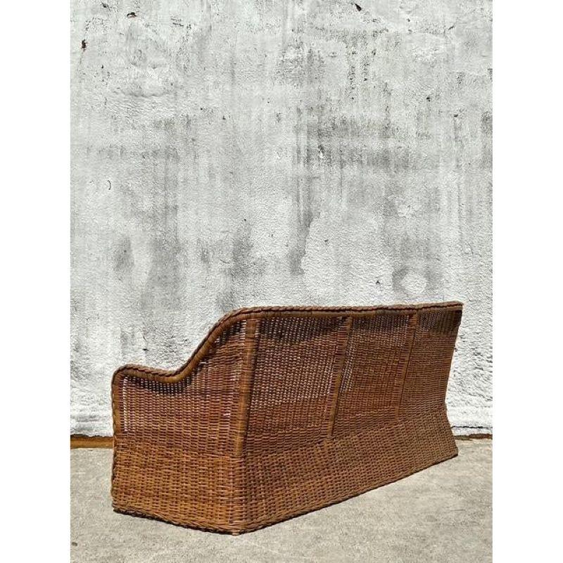 Bring the essence of effortless coastal living into your home with this exceptional Vintage Braided Rattan Sofa, a piece that exudes laid-back sophistication and timeless charm. This meticulously hand-woven sofa features a gracefully curved