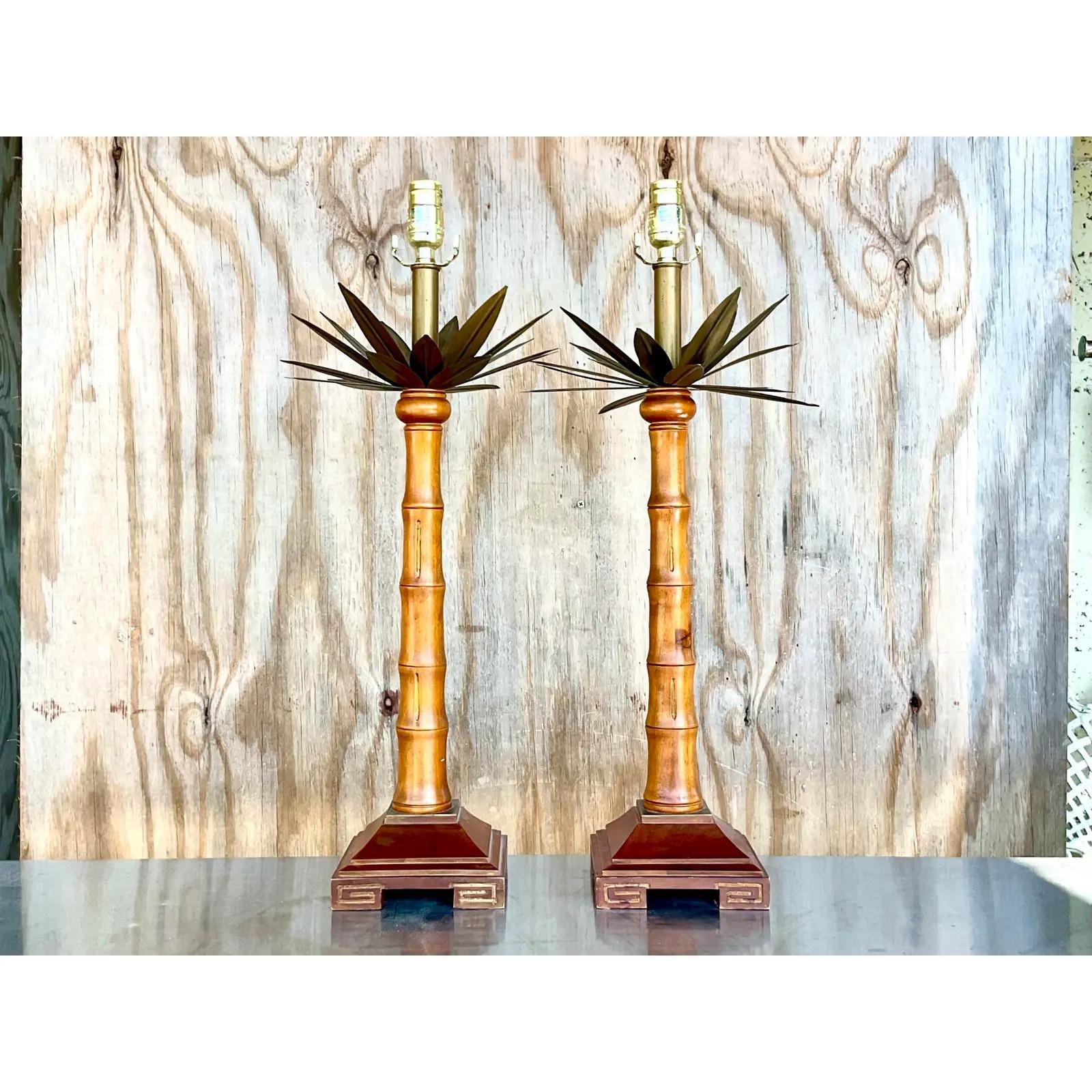 Fantastic pair of vintage candlestick lamps. Beautiful palm tree design with big brass palm fronds. Greek Key carving on the plinth. Acquired from a Palm Beach estate.