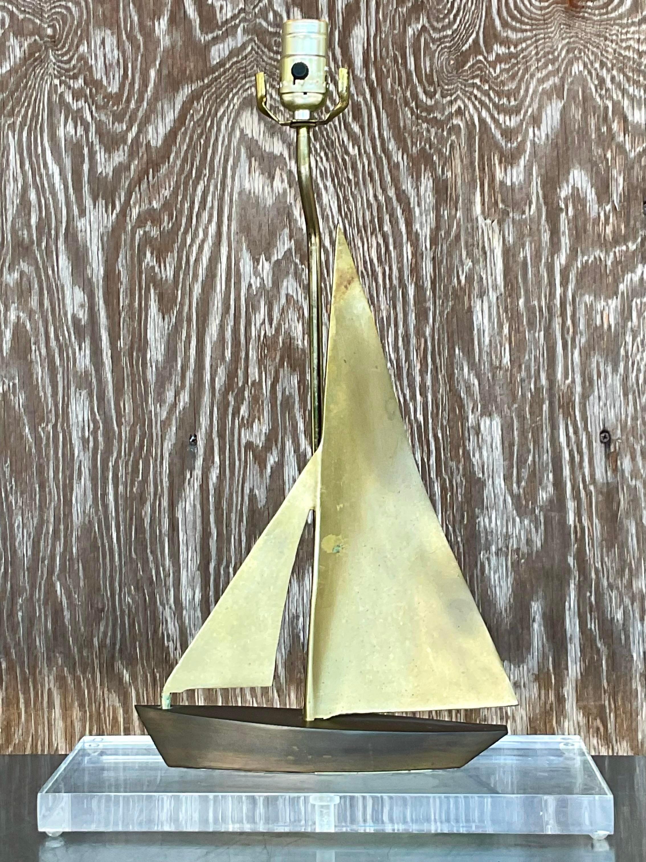Vintage Coastal table lamp. Beautiful brass sailboat sailing on a Lucite plinth. Acquired from a Palm Beach estate.