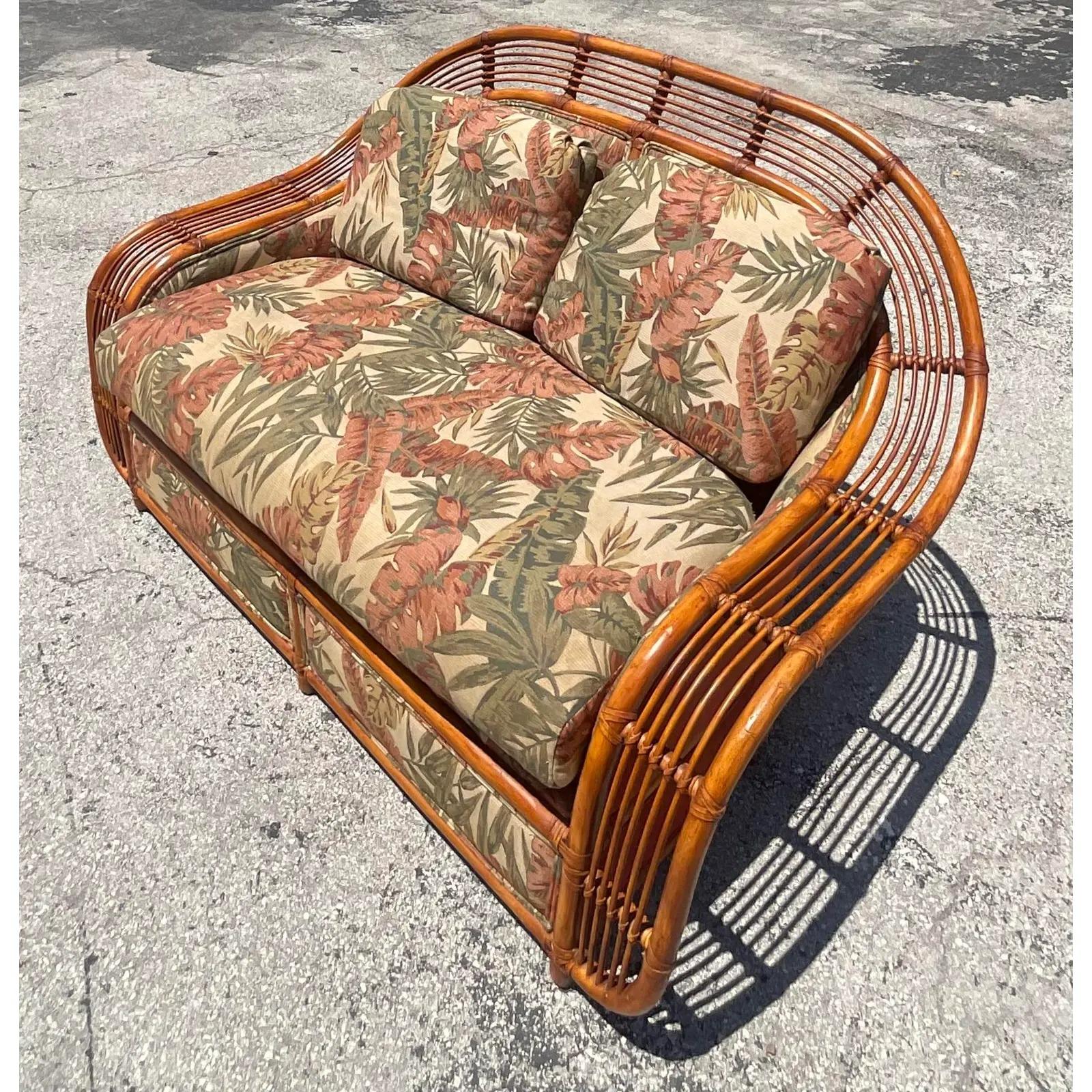 An incredible pair of vintage Coastal rattan sofa and chair. Made by the iconic Henry Olko for Willow and Reed. Part of the coveted Brielle series. Unmarked. Acquired from a Palm Beach estate.