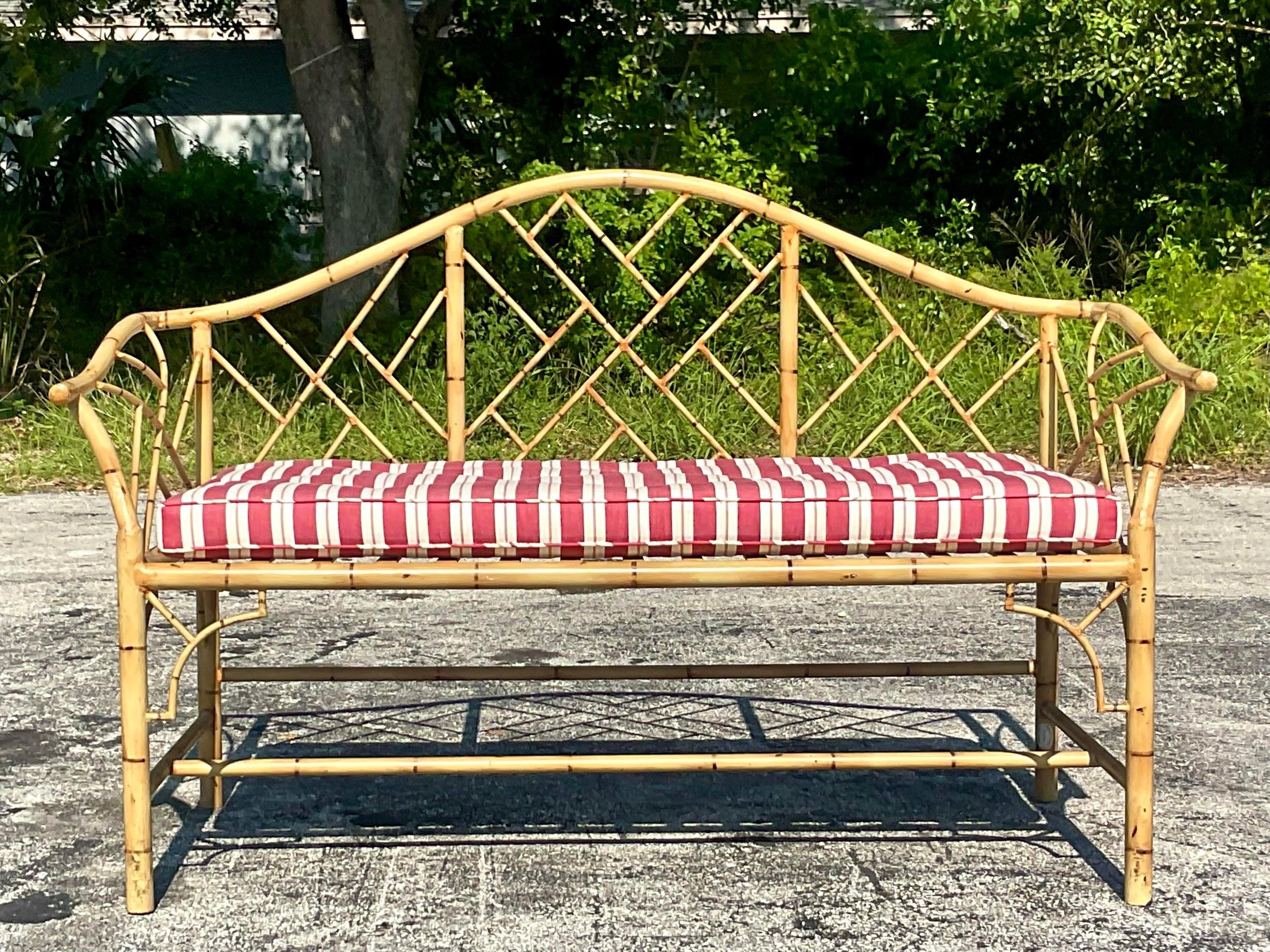 A fabulous vintage Coastal metal bench. A chic hand painted bamboo design with a coordinating cushion and Chinese Chippendale frame. Made by the iconic Chris Briger of the fabulous Gusto store in Palm Beach. Acquired from a Palm Beach estate.