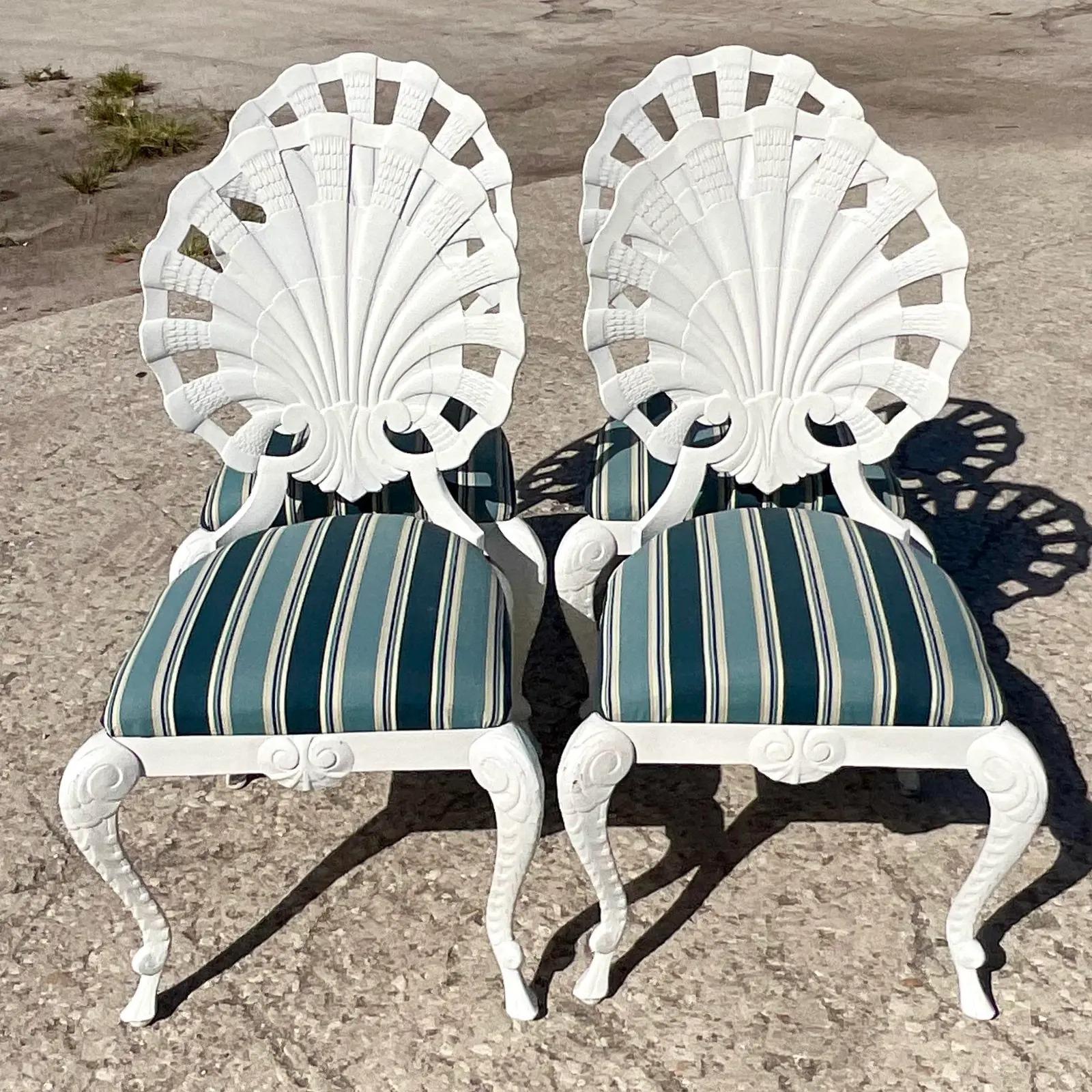 Fabulous set of four vintage Coastal outdoor dining chairs. Made by the iconic Brown Jordan. Done in a cast aluminum with a bright white finish. A chic striped upholstery in shades of blue. Unmarked. Acquired from a Palm Beach estate.