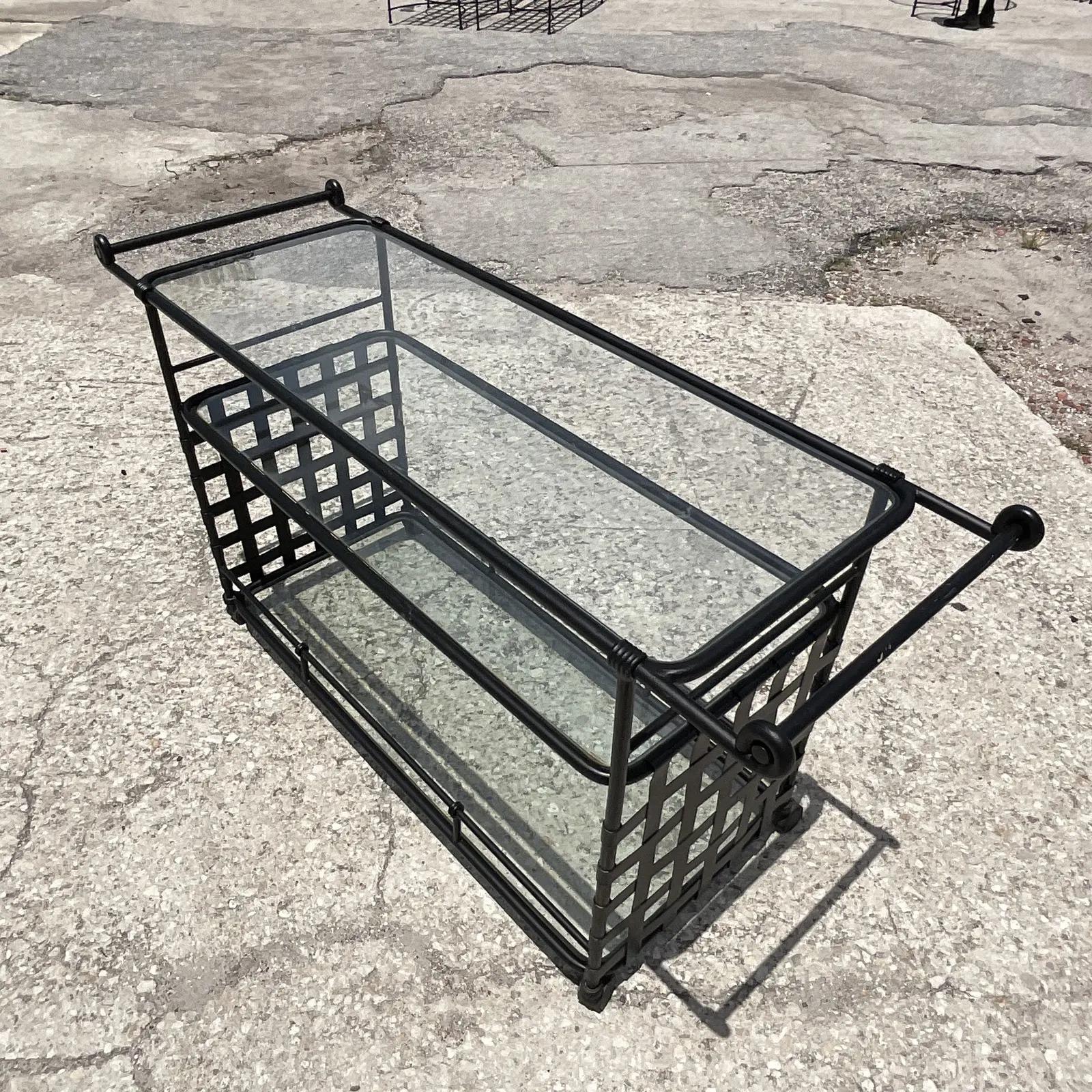 Fantastic vintage Coastal bar cart. Made by the iconic Brown Jordan in the coveted Florentine design. A matte black finish on a wrought iron frame. Inset glass shelves. Unmarked. Acquired from a Palm Beach estate.