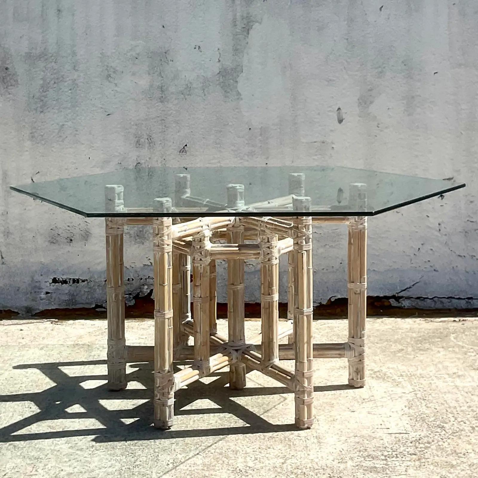 A fantastic vintage coastal dining table. A chic bundled rattan in a gorgeous cerused finish. Octagon shaped glass rests on top. Done in the manner of McGuire. Acquired from a Palm Beach estate.