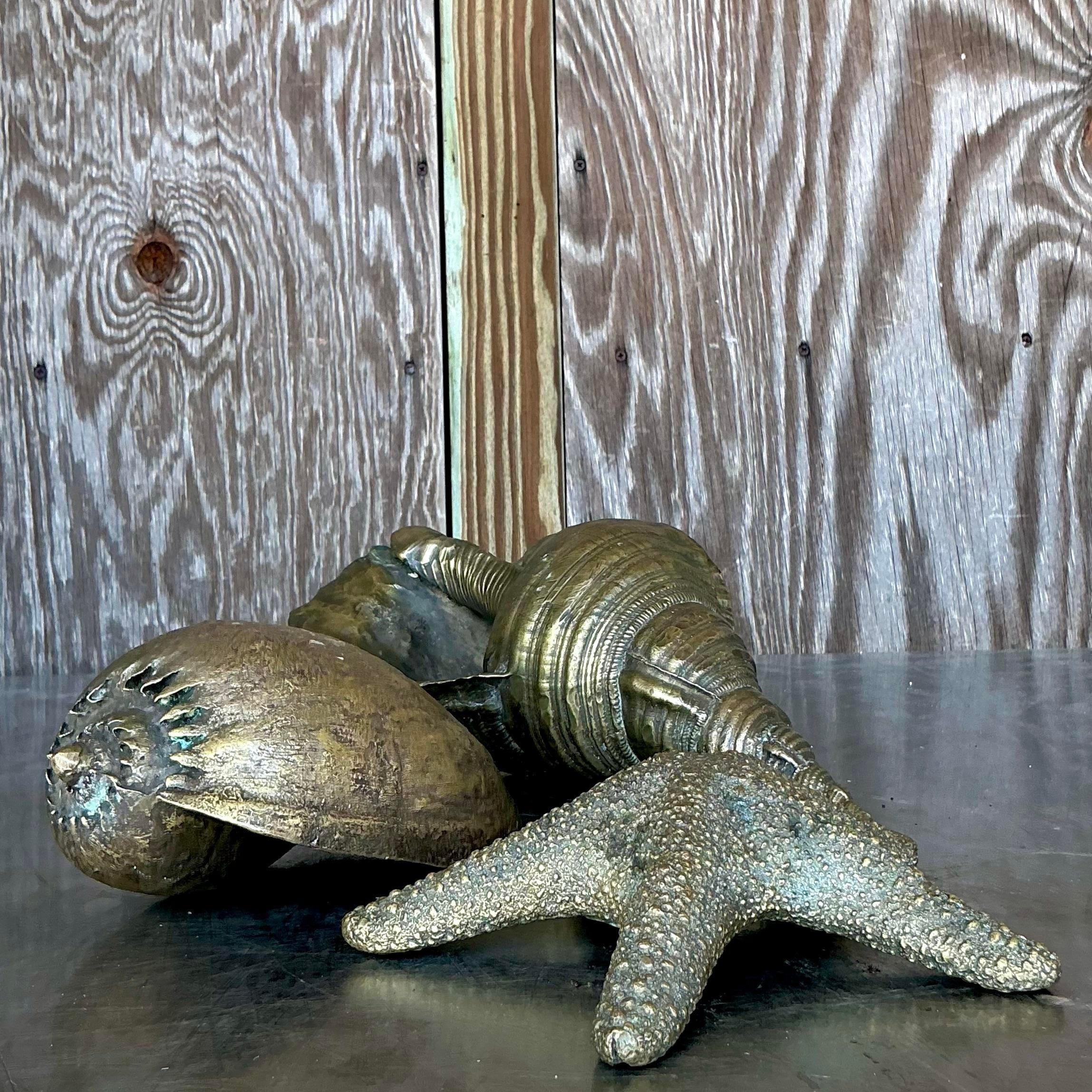 Porta il fascino del mare nel tuo arredamento con questo set di conchiglie vintage in ottone brunito. Ogni pezzo presenta una finitura calda e brunita, che cattura la bellezza delle conchiglie naturali con un fascino elegante e senza tempo. Perfette