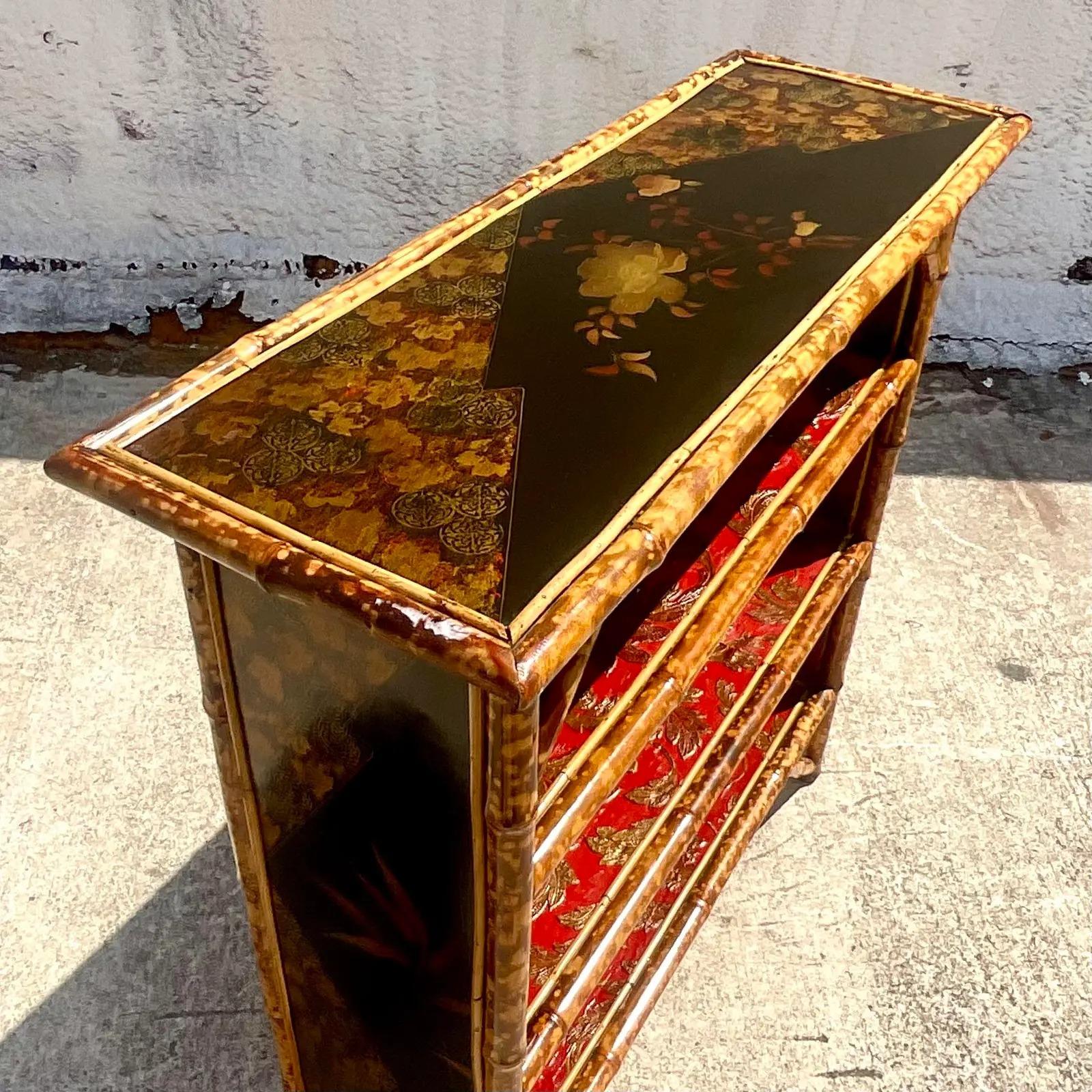 A fantastic vintage Coastal etagere. Chic burnt bamboo frame with inset black lacquer panels. Hand painted chinoiserie detail. Shelves lines with painted tin panels. A real feast for the eyes. Acquired from a Palm Beach estate.