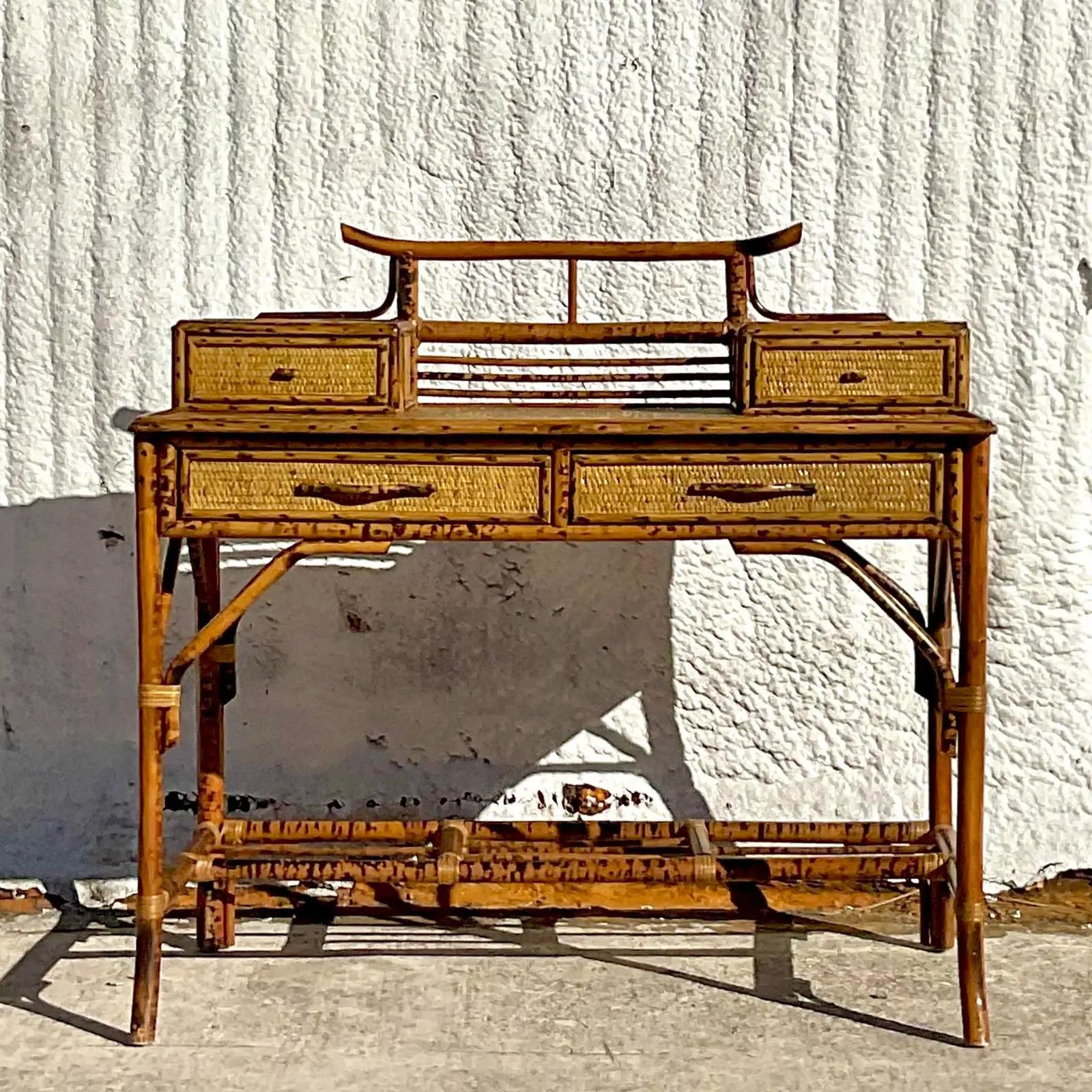 An outstanding vintage Coastal writing desk. Beautiful burnt bamboo frame with inset woven rattan panels. A chic diamond design with pagoda touches. Acquired from a Palm Beach estate.