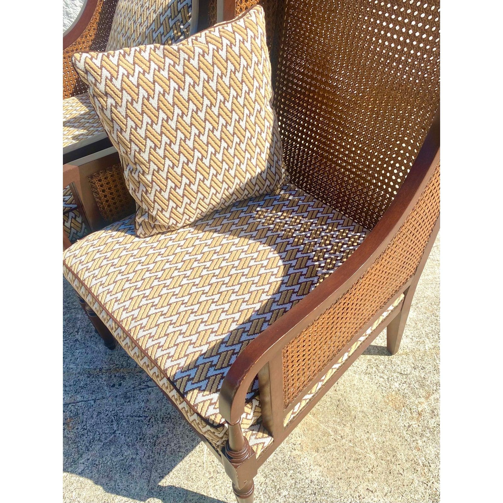 Fantastic pair of coastal wingback chairs. Beautiful high back profile with inset cane panels. Upholstered in a classic David Hicks print. Acquired from a Palm Beach estate.