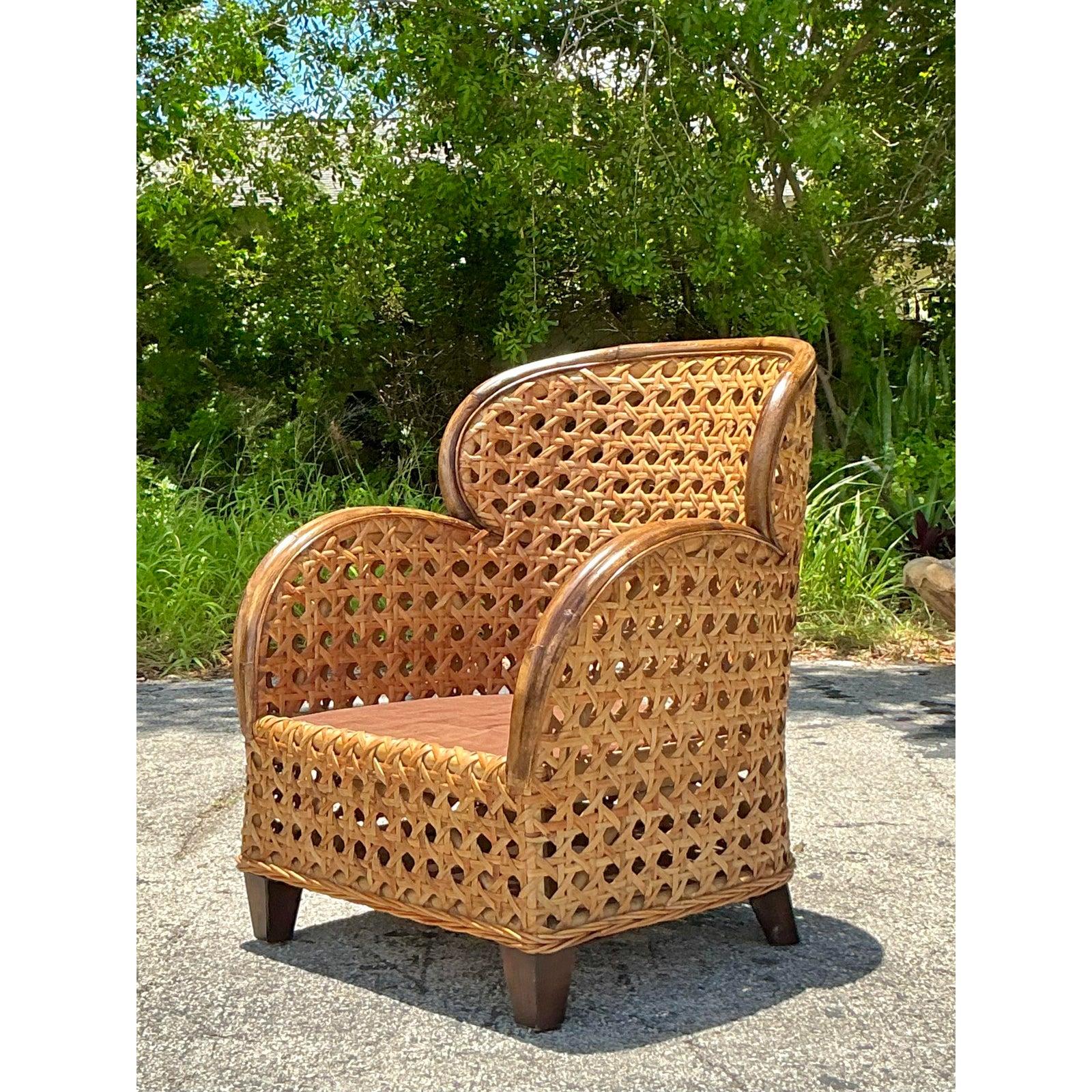 Embrace a touch of the tropics with this vintage monumental caned armchair, a stunning statement piece that exudes natural elegance and artisan craftsmanship. The chair's commanding silhouette is defined by a high, rounded back and generous,