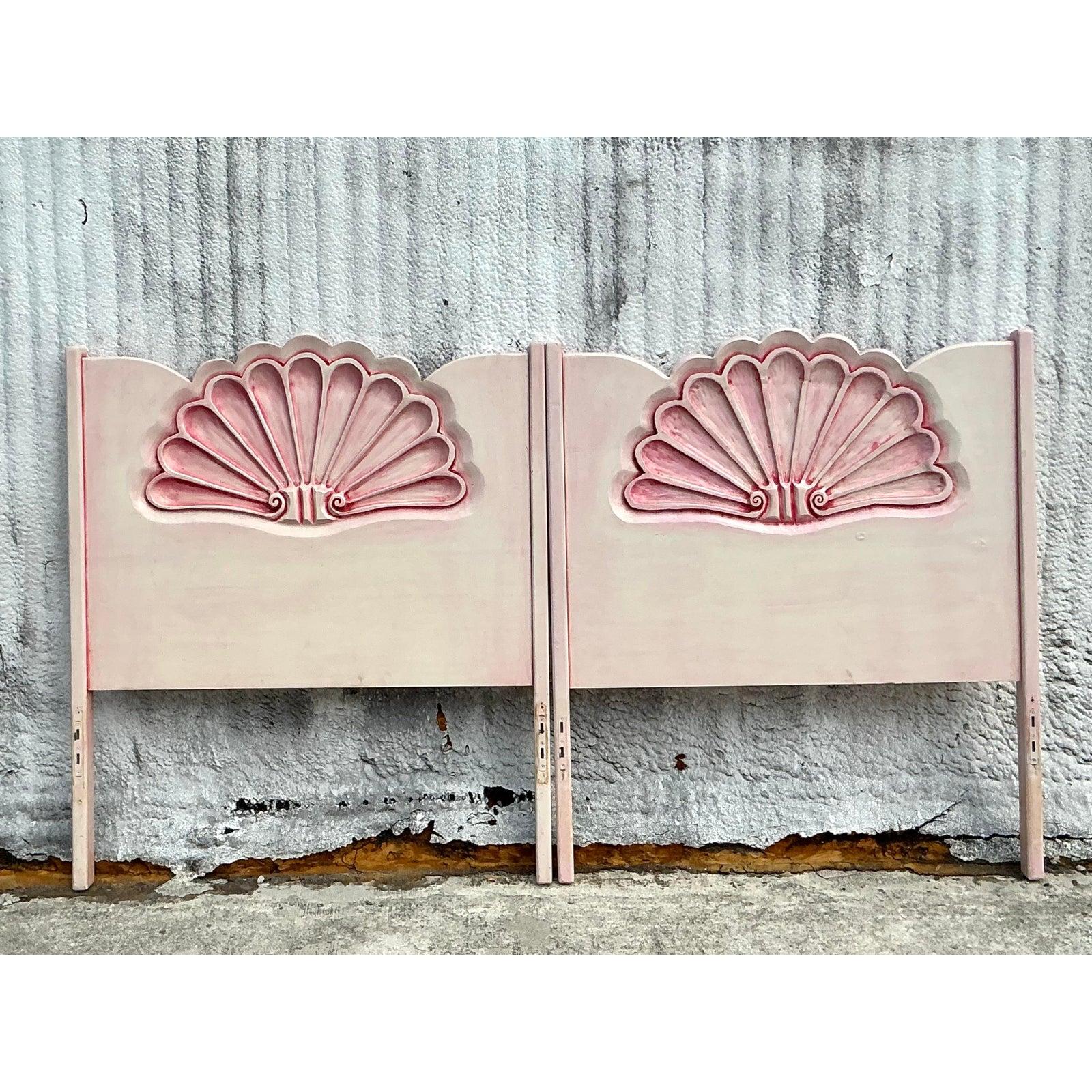 Elevate your bedroom with this charming pair of vintage coastal-inspired twin headboards. Beautifully crafted with a carved clamshell motif, these headboards exude seaside elegance with their soft pink and white finish. The delicate scalloped design
