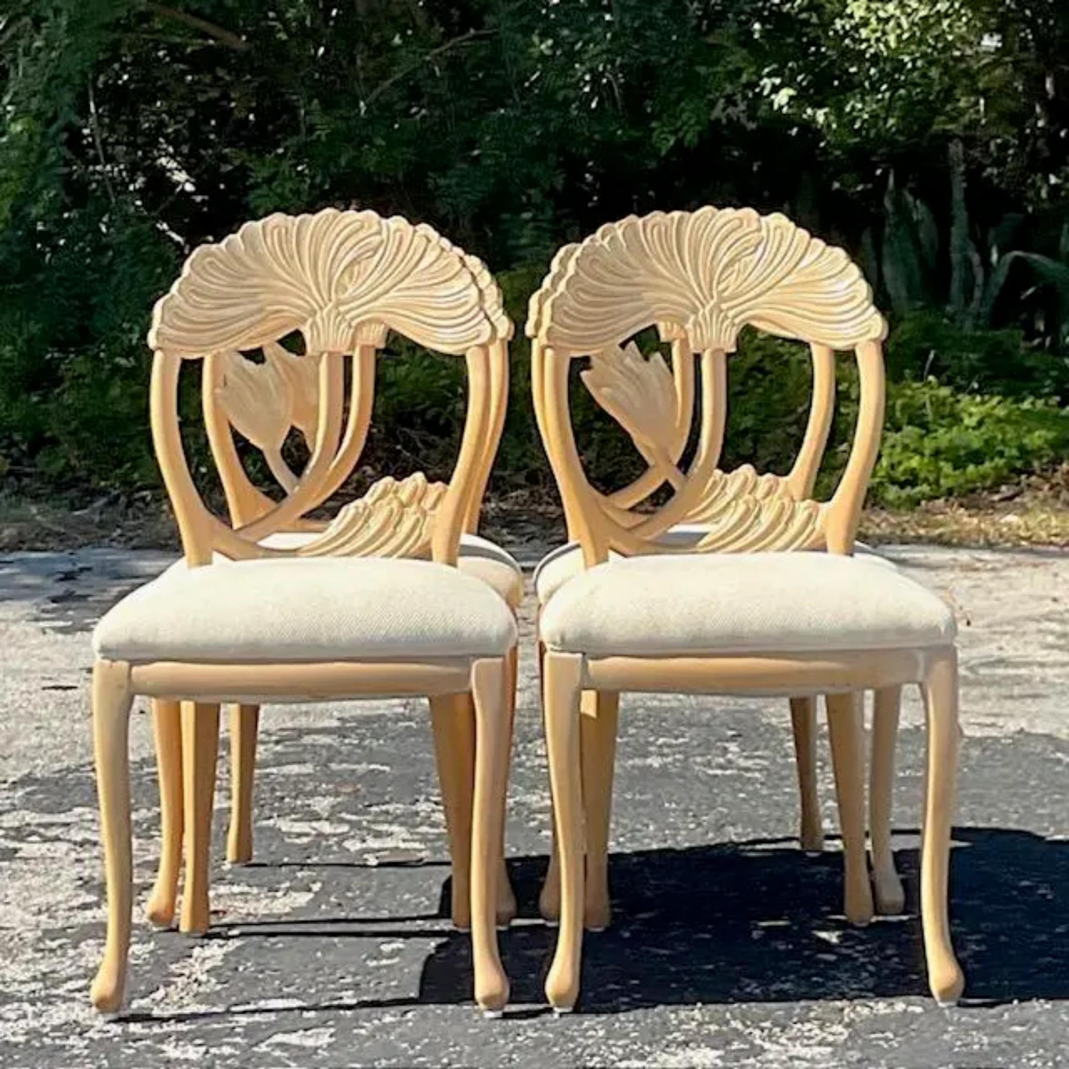 A fabulous set of four Coastal wood dining chairs. A chic hand carved Lotus blossom in a pale Ash wood. Acquired from a Palm Beach estate.