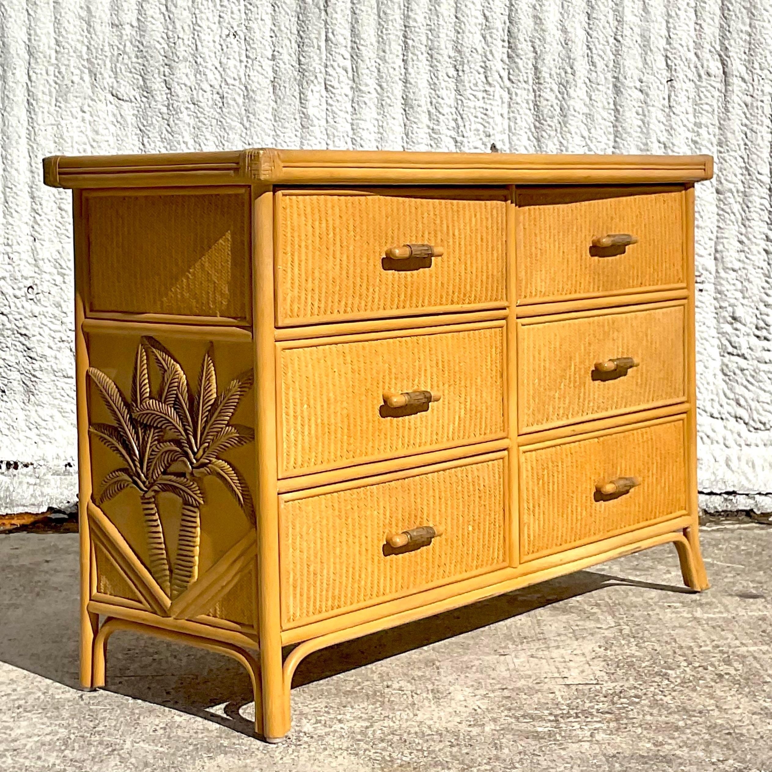 A fantastic vintage Coastal six drawer dresser. A chic woven rattan with carved palm trees on the side. Really takes it to the next level. Acquired from a Palm Beach estate.
