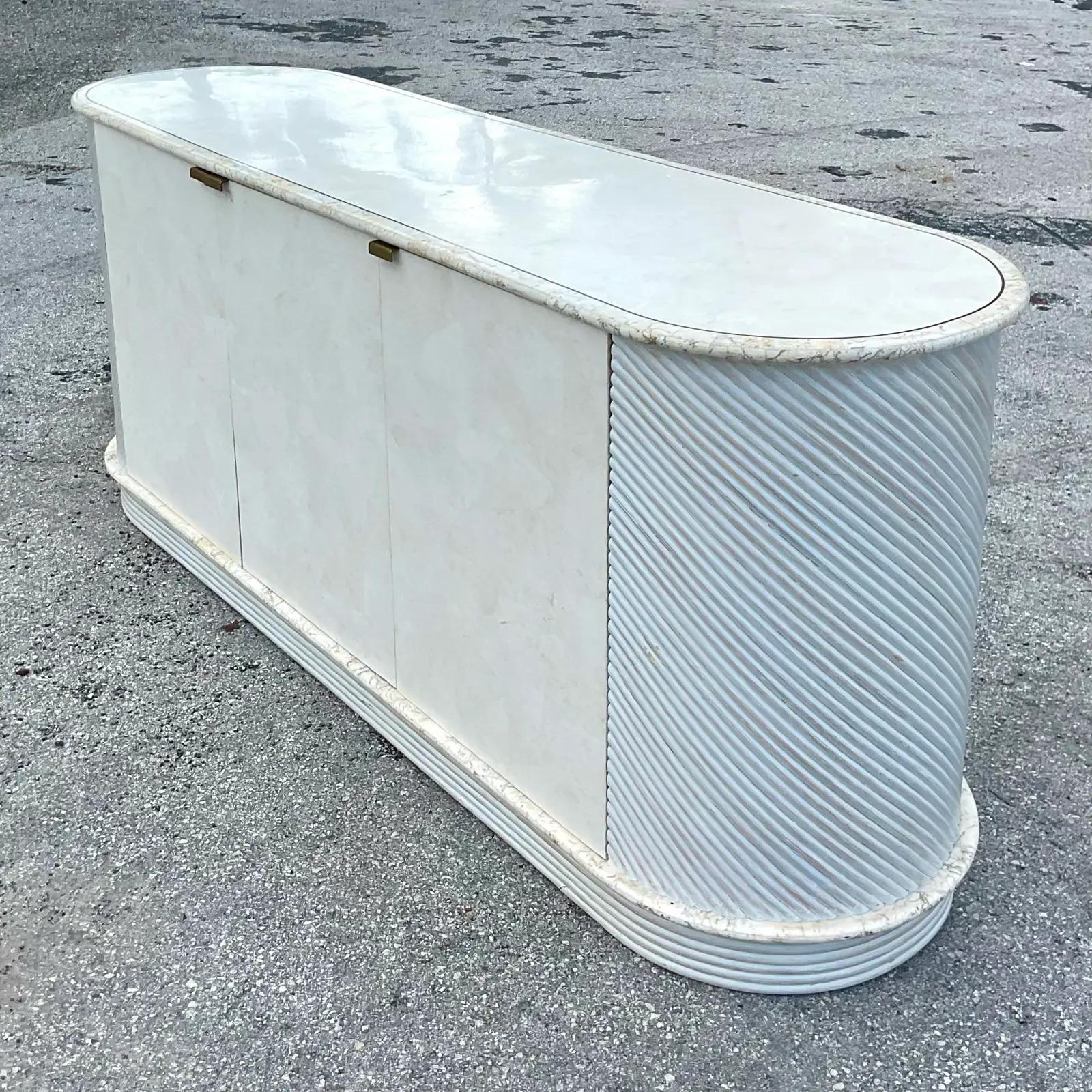 Fantastic vintage Coastal credenza. A chic design by the iconic Casa Bique group. Tessellated stone top and doors with cerused pretzel rattan ends. A real showstopper. Acquired from a Palm Beach estate.