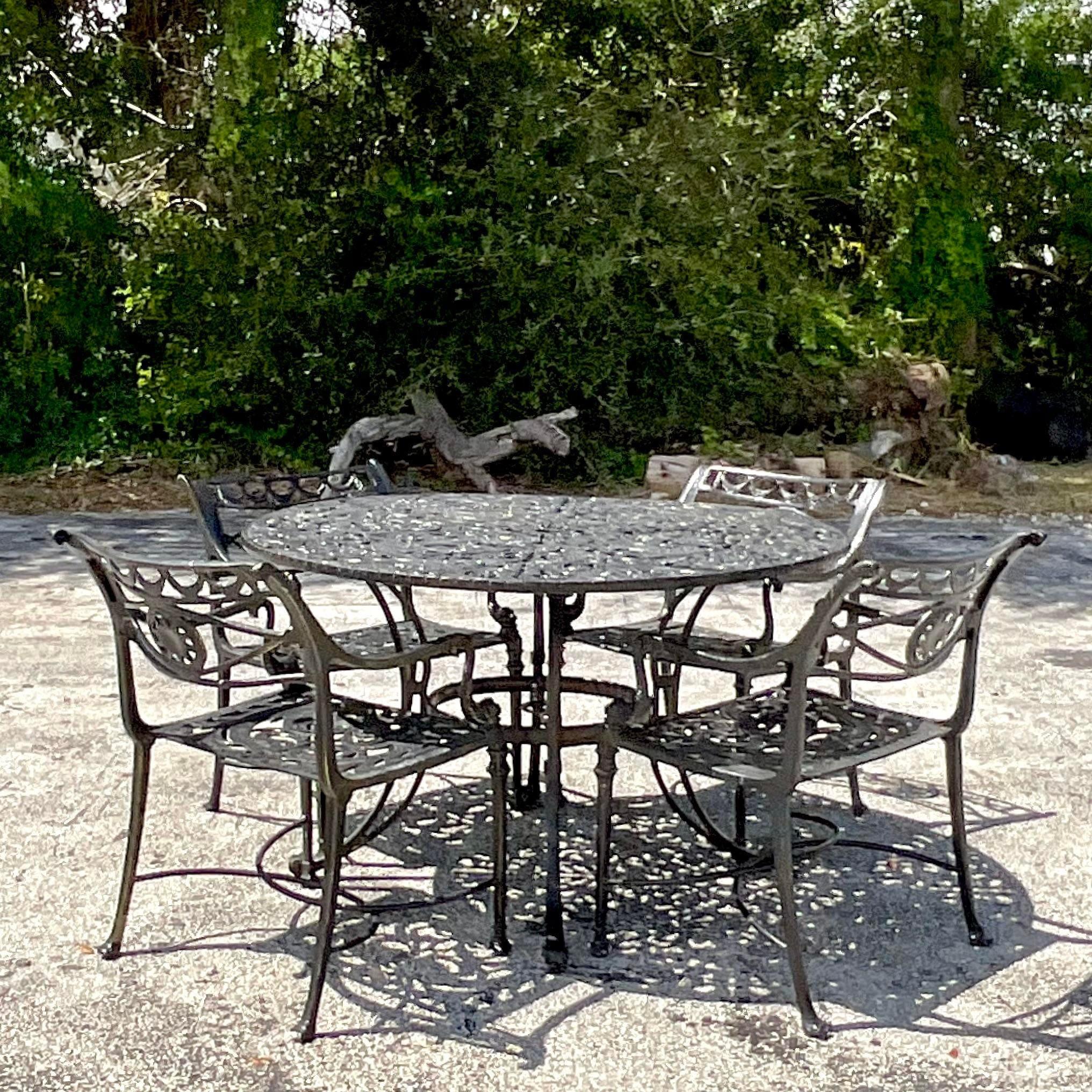 A fabulous vintage Coastal outdoor dining table. A chic cast aluminum in a gloss black finish. Coordinating Dolphin chairs and another table also available on my page. Acquired from a Palm Beach estate.