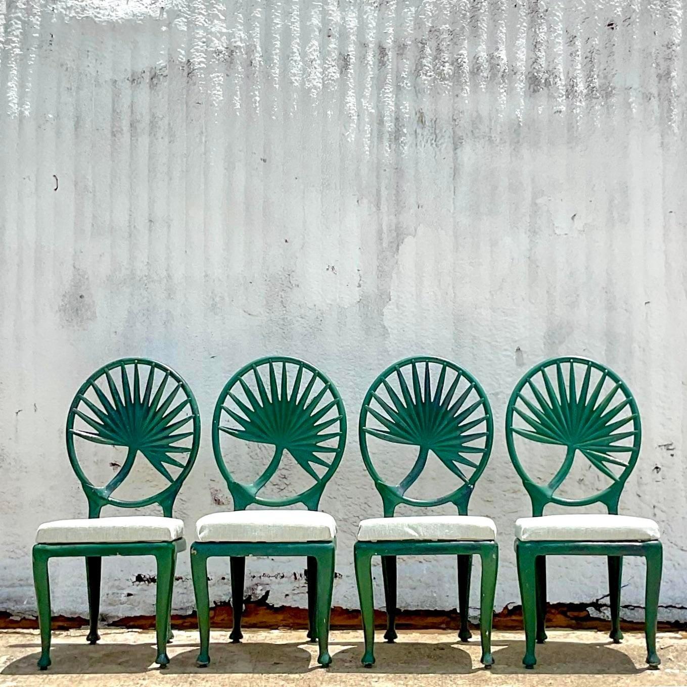 A fabulous set of four vintage cast aluminum outdoor chairs. Done in the manner of a brown Jordan with the iconic palm frond design. Cushions included. Acquired from a Palm Beach estate.