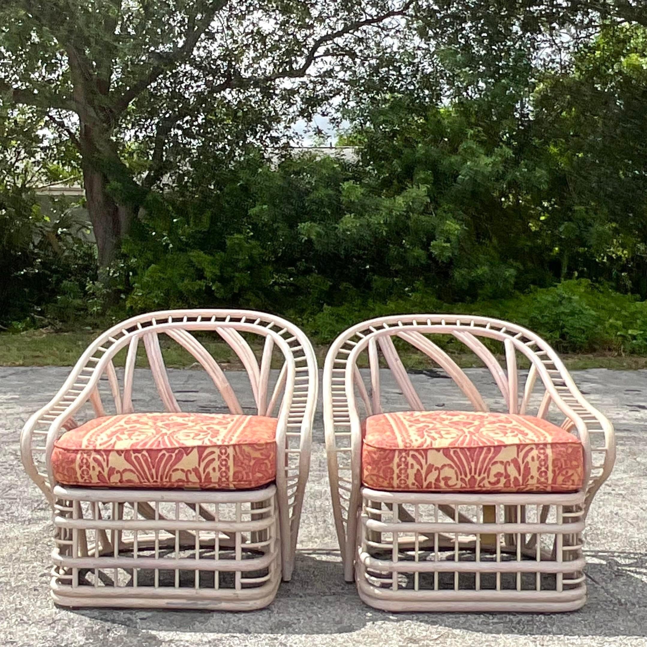 A fabulous pair of vintage Coastal lounge chairs. A chic cerused bent rattan in a dynamic fluid design. Rare and unusual. Acquired from a Palm Beach estate.