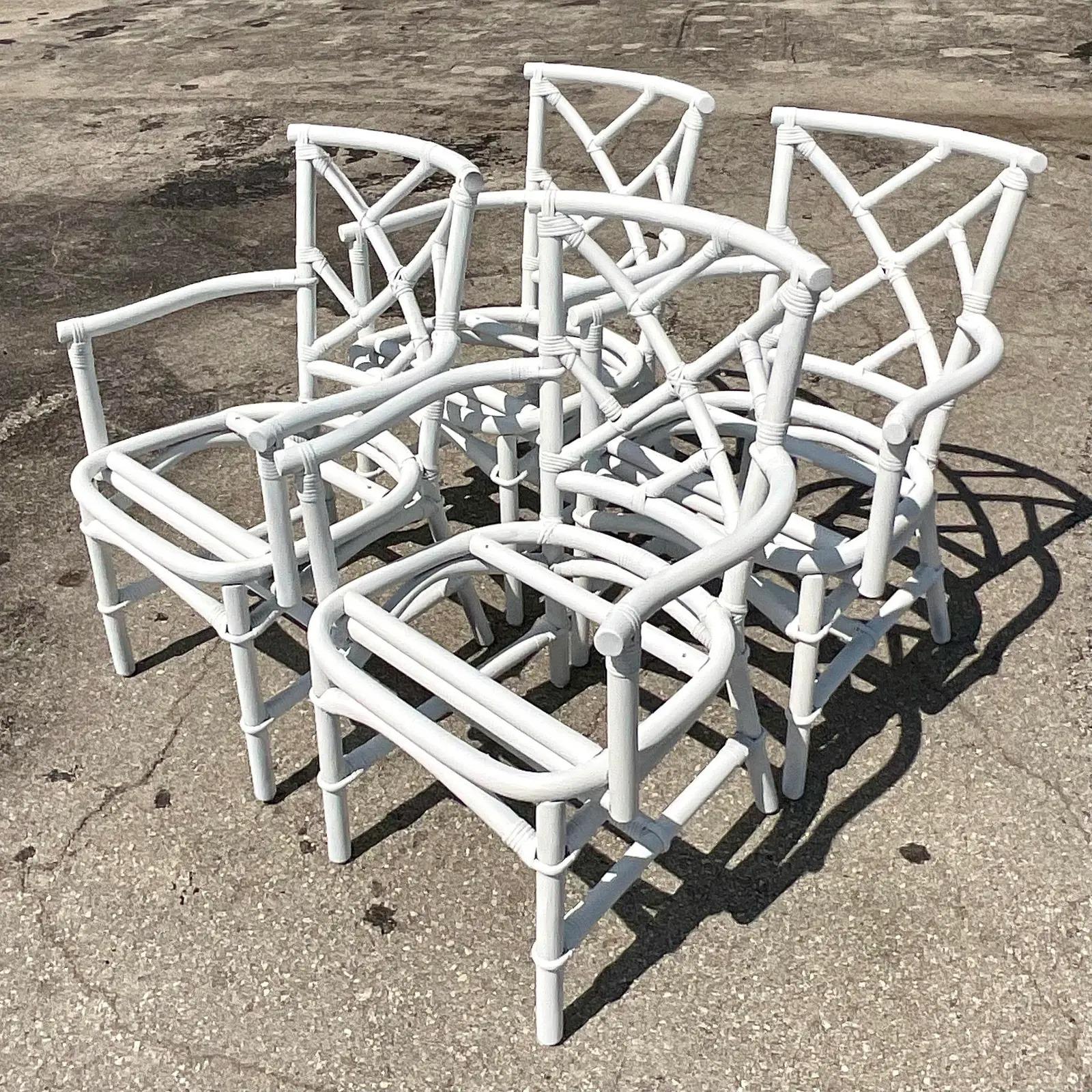 Fantastic set of four vintage Coastal dining chairs. Done in the manner of Ficks Reed with the iconic Chinese Chippendale design. Freshly painted white in a semi gloss finish. All seats will be included. Acquired from a Palm Beach estate.