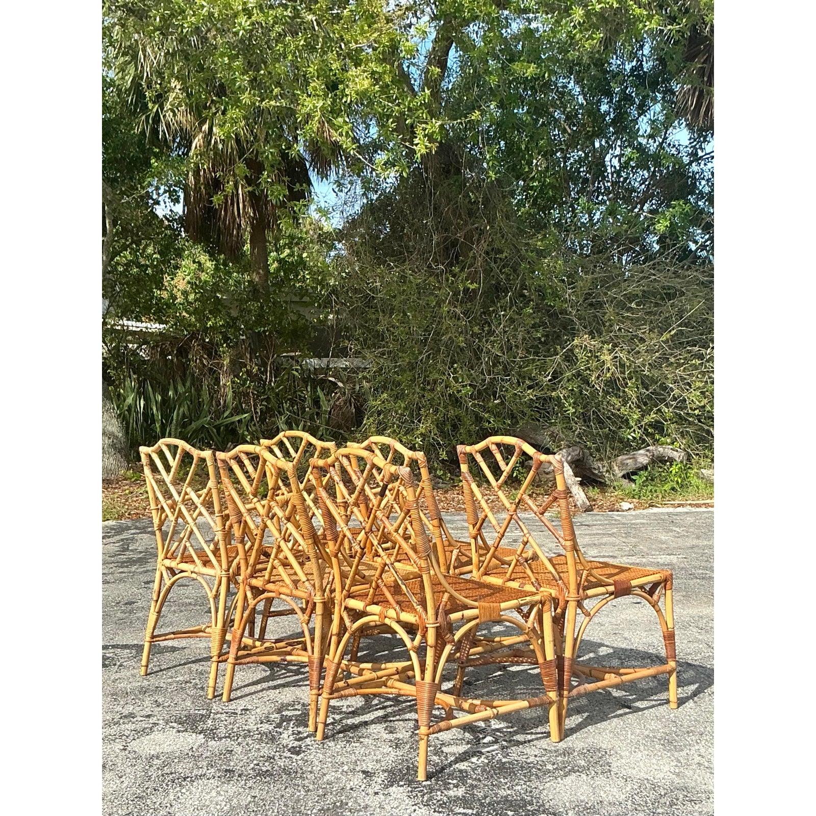 Add timeless coastal charm to your dining space with this set of six vintage Chinese Chippendale dining chairs. Featuring a beautifully intricate bamboo and rattan frame with an iconic lattice-back design, these chairs exude tropical elegance and