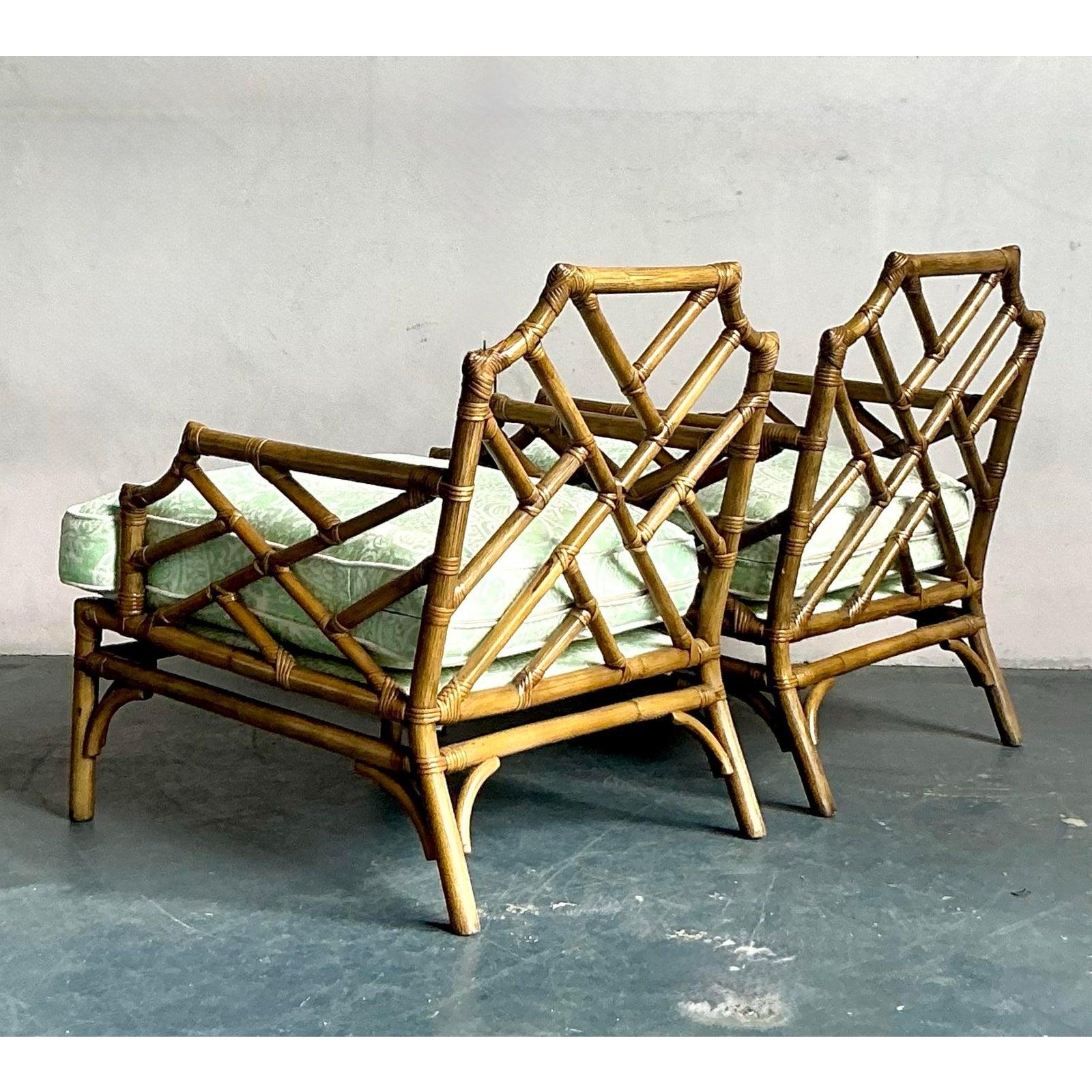 Scopri questa raffinata coppia di poltrone cinesi vintage in rattan in stile Chippendale, perfetta incarnazione dell'eleganza costiera e del design classico. Queste sedie presentano l'iconico traforo in finto bambù, meticolosamente realizzato in