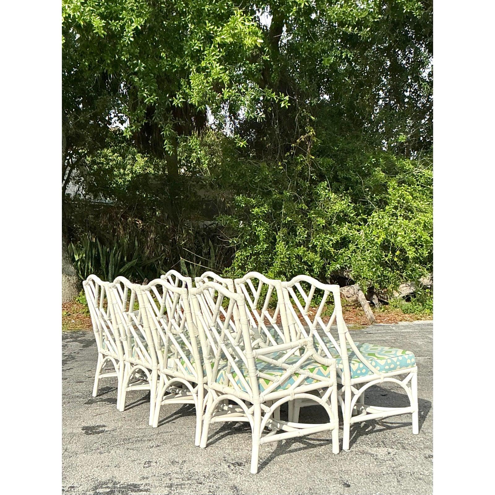 Enhance your dining space with this stunning set of eight vintage coastal Chinese Chippendale rattan dining chairs. Crafted with intricate lattice-back detailing and a gracefully curved silhouette, these chairs exude timeless elegance and casual