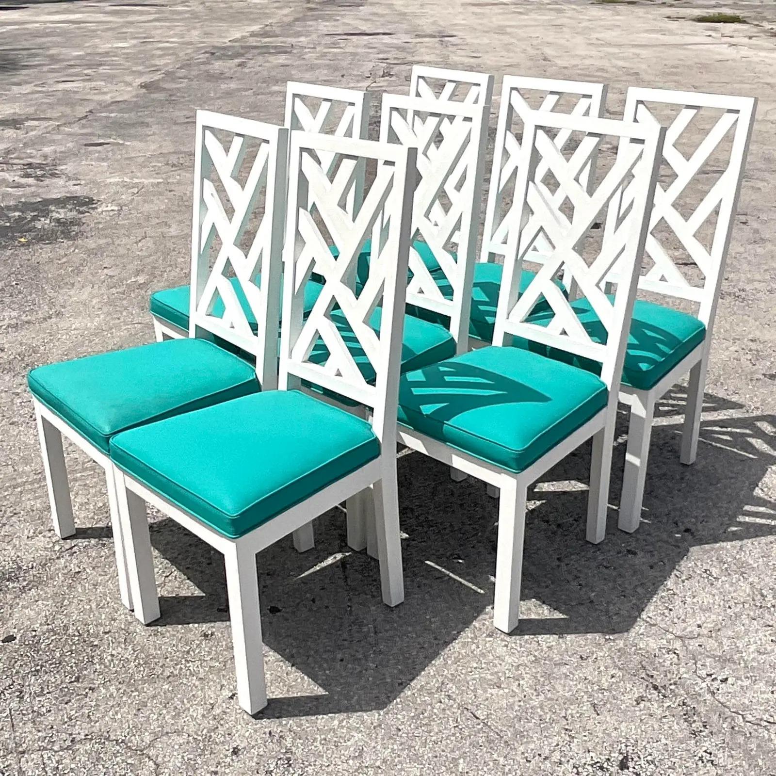Fabulous set of 8 vintage Coastal dining chairs. Chic white lacquered finish on a Chinese Chippendale design. Attached bright teal blue seats with welting trim. 

The chairs are in great vintage condition. Minor scuffs and blemishes appropriate to