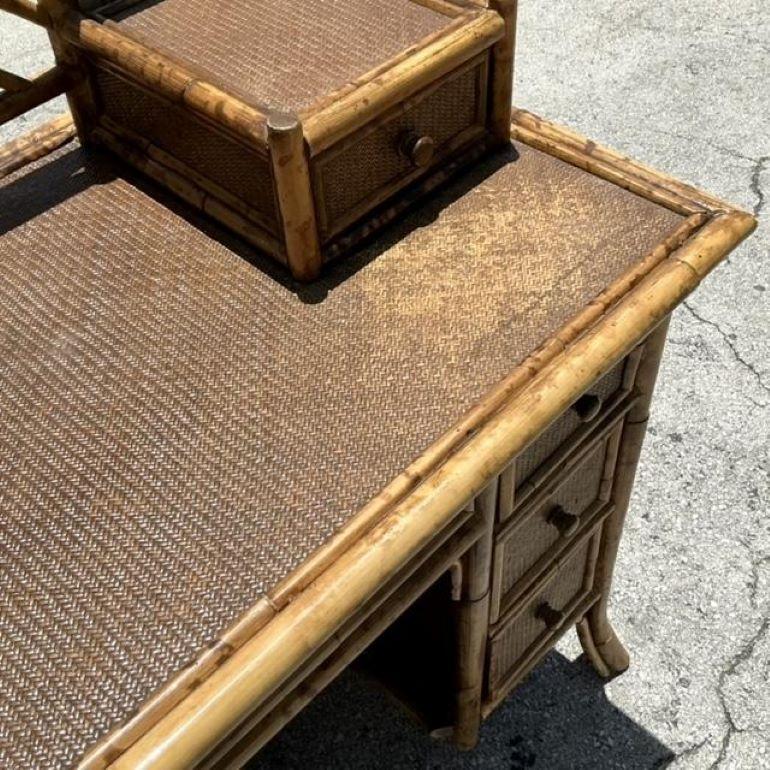 Migliora il tuo spazio di lavoro con la Scrivania Chippendale Cinese in rattan intrecciato Vintage By. Caratterizzata da elementi classici del design Chippendale con un tocco costiero, questa scrivania combina dettagli eleganti con un'atmosfera