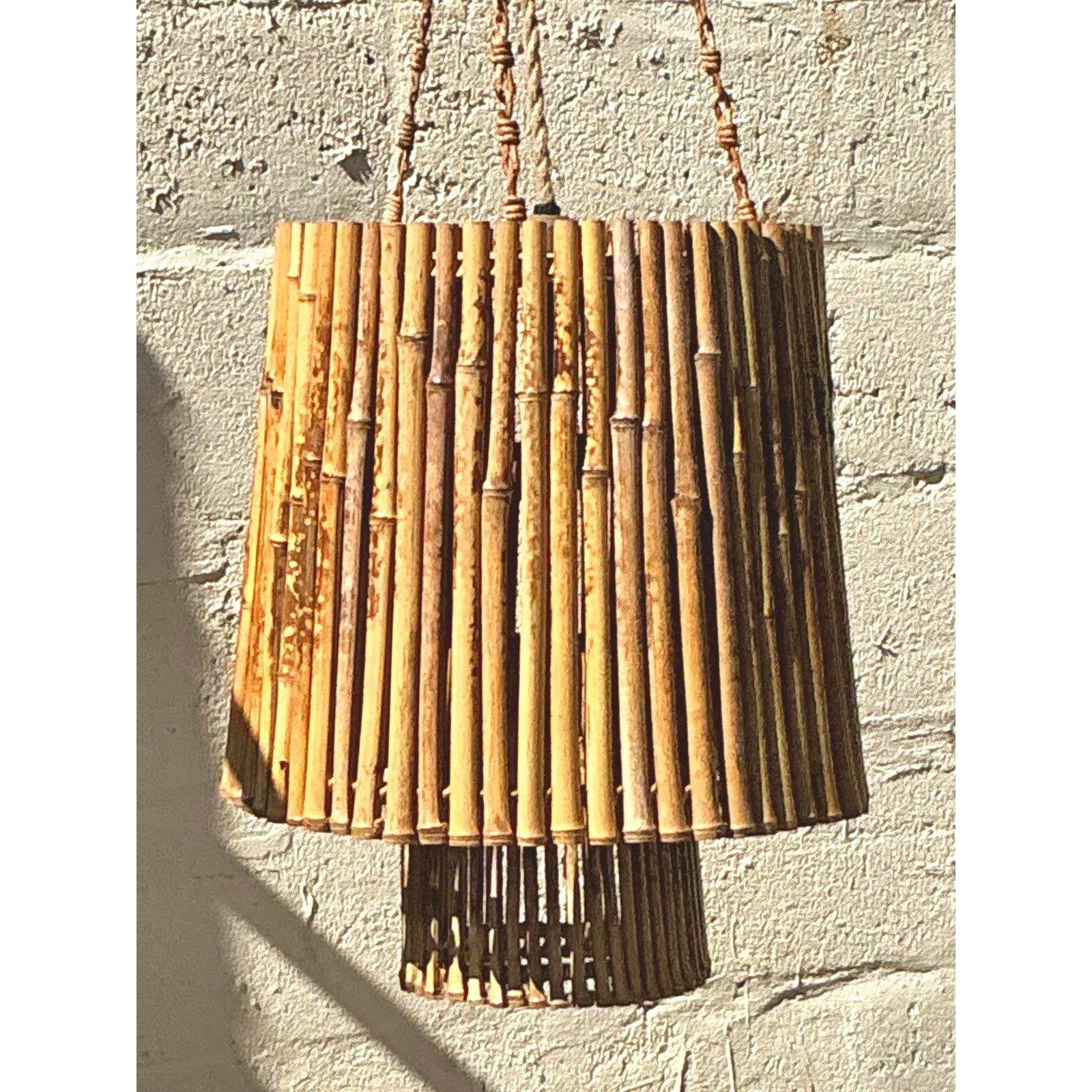 Bring a touch of organic elegance to your interiors with this charming Vintage Coastal Bamboo Chandelier. Crafted from natural bamboo reeds and suspended by braided cords, this piece embraces the laid-back, earthy appeal of coastal and bohemian