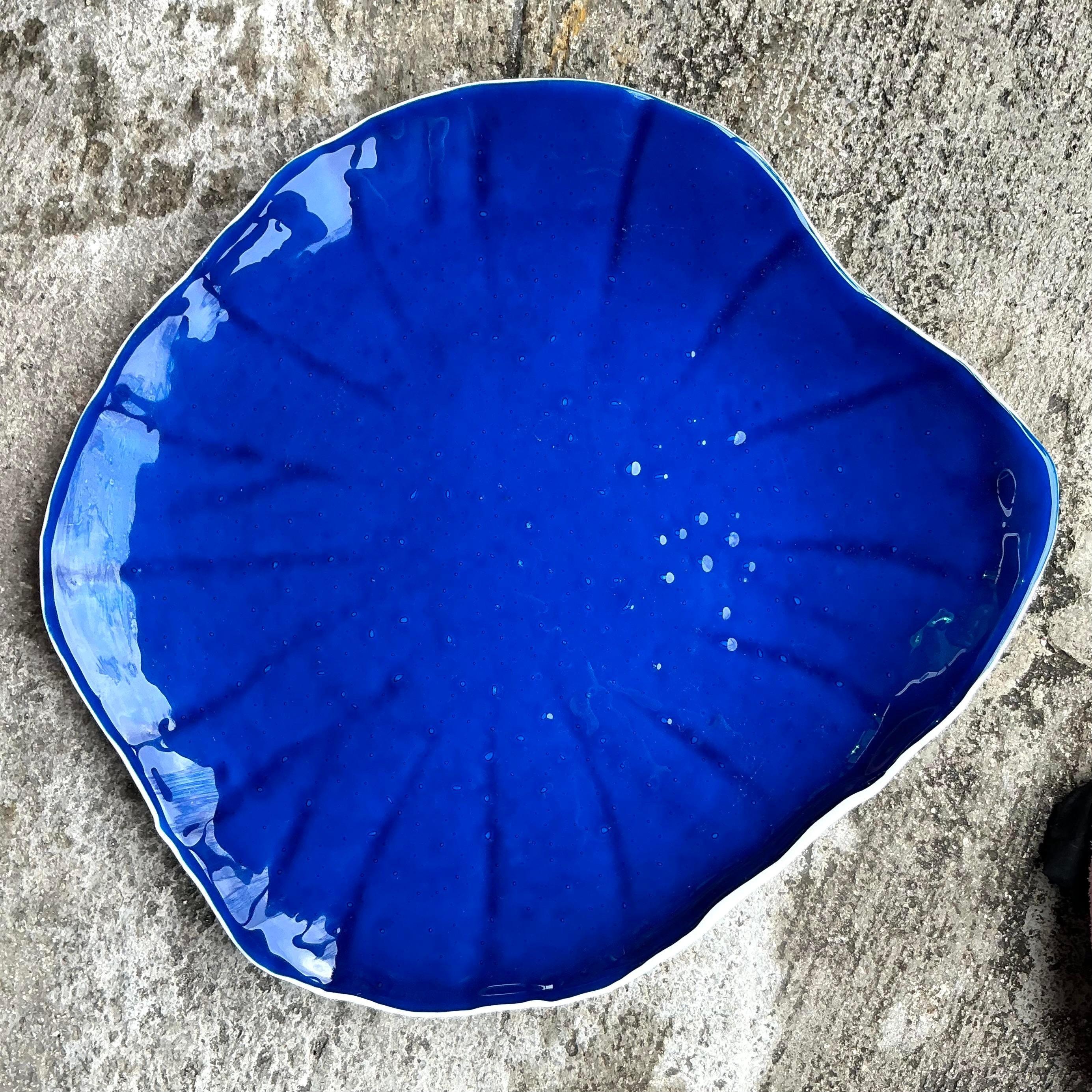 Ce plateau côtier vintage, fabriqué à partir d'un riche verre cobalt, ajoute une touche vibrante de couleur et d'élégance à n'importe quel espace. Sa teinte bleu profond rappelle les vagues de l'océan, ce qui en fait un accent parfait pour une