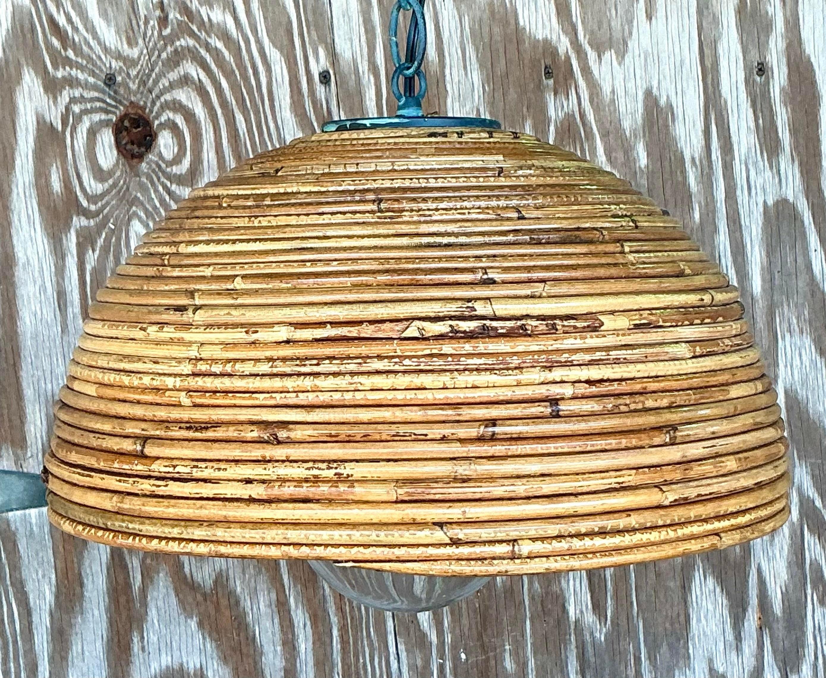 Dai un tocco di mare al tuo spazio con questo ciondolo vintage a spirale in canna da pesca. Caratterizzata da uno splendido design intrecciato che imita le trame naturali della costa, questa lampada a sospensione aggiunge un'atmosfera calda e