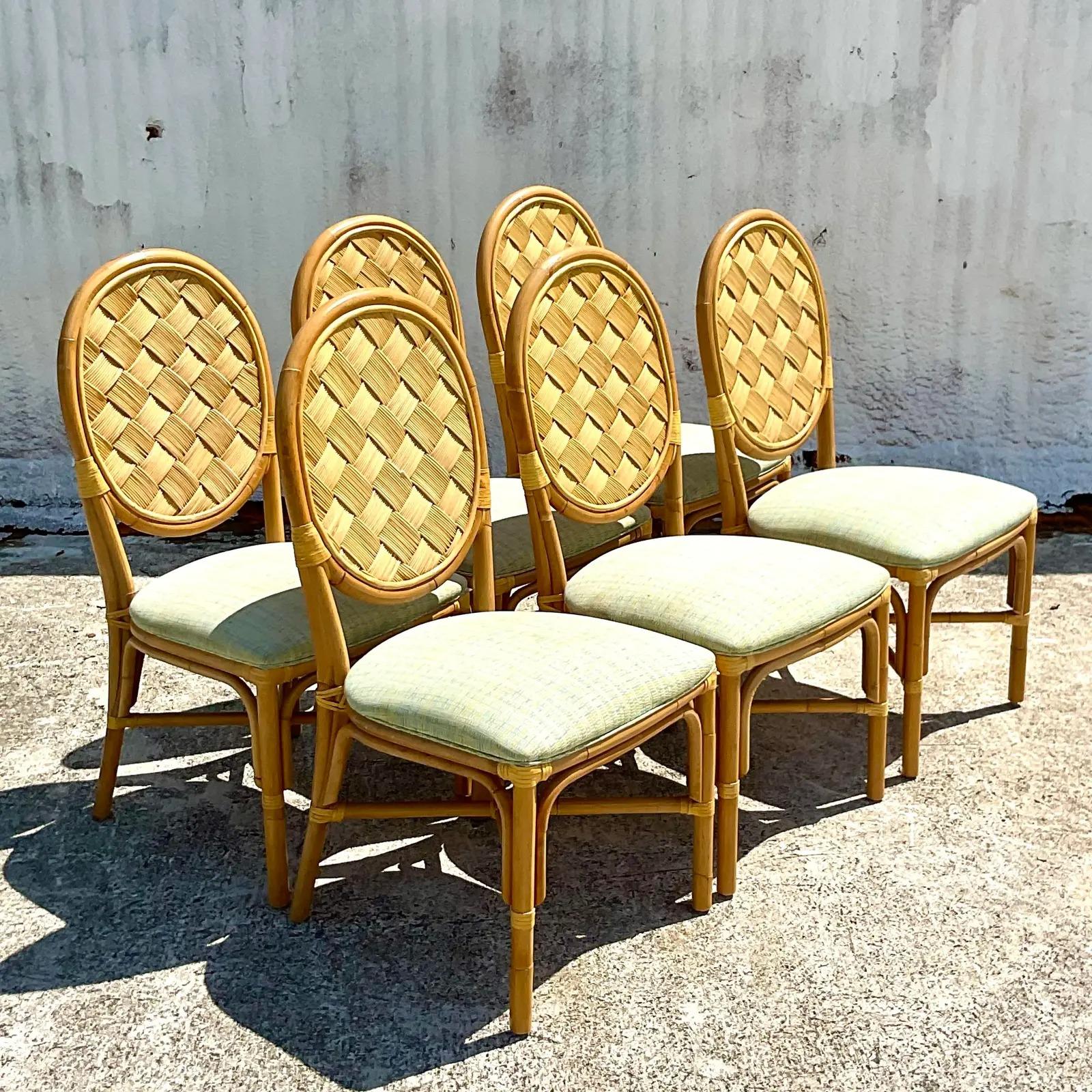 Fantastic set of six vintage Coastal dining chairs. Beautiful medallion back with a chic woven rattan inset panel. Done in the manner of a John Hutton for Donghia. Two sets of six available for a larger set. Acquired from a Palm Beach estate.