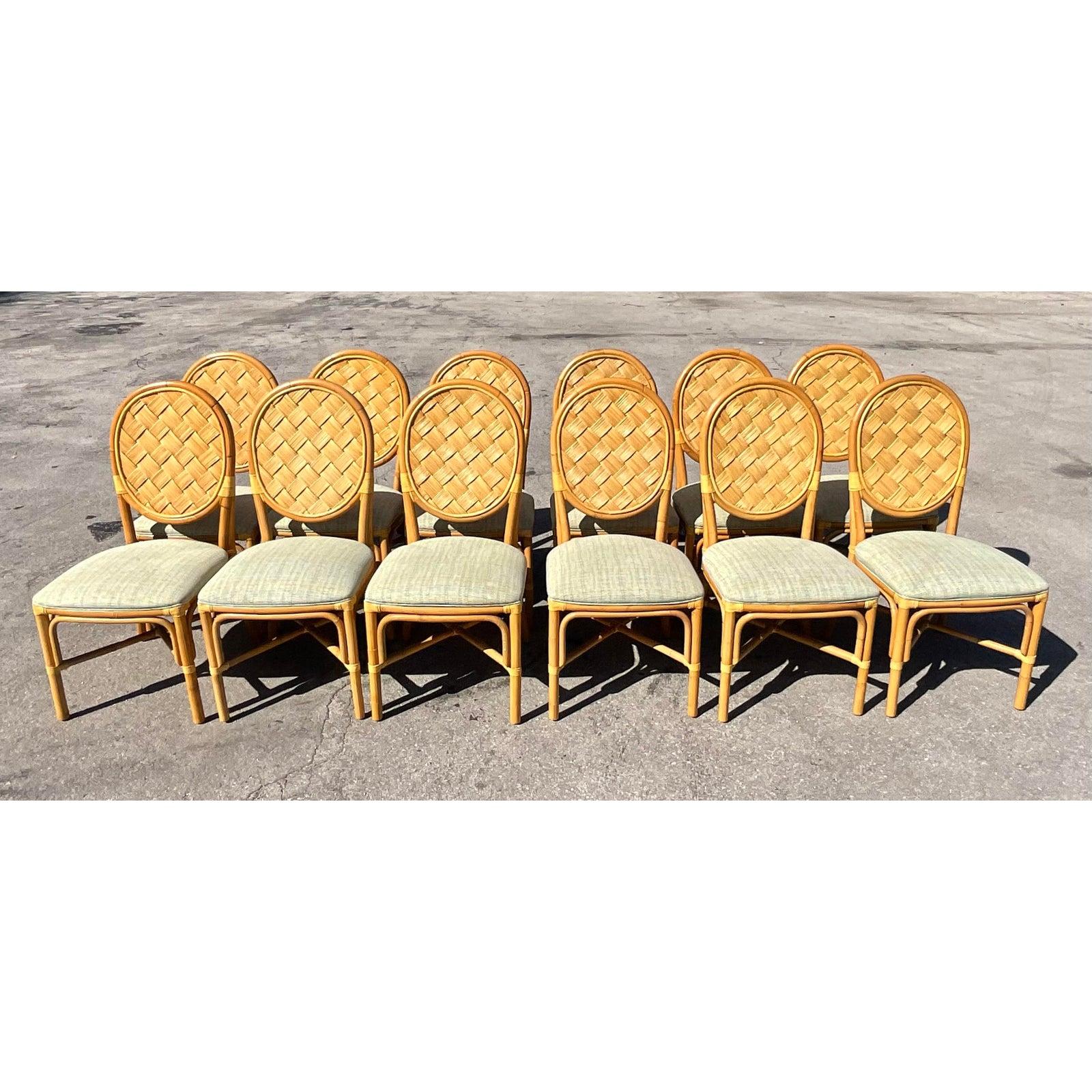 Incredible set of 12 vintage Coastal woven rattan dining chairs. An iconic weave structure done in the manner of John Hutton for Donghia. Made famous by His legendary Block Island collection. Upholstered in a lovely pale blue green printed fabric.