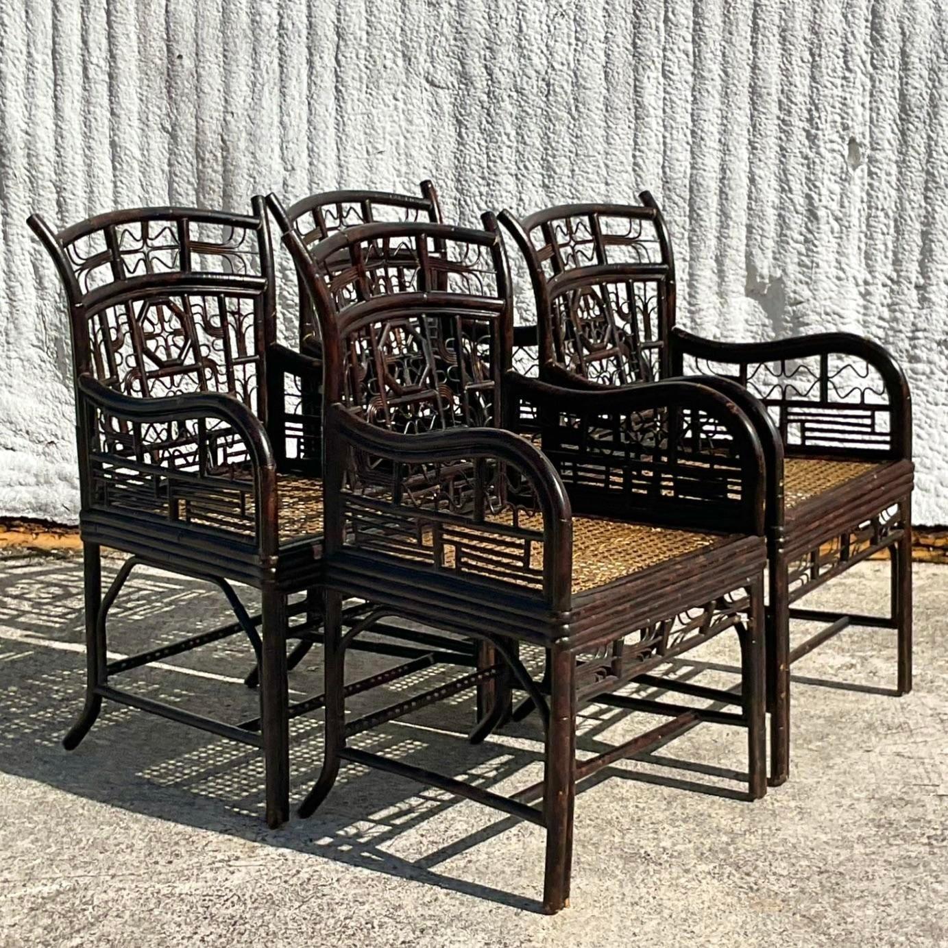 A stunning set of four vintage Coastal dining chairs. A chic ebony rattan in an updated Brighton design. Inset woven cane panel seat. Acquired from a Palm Beach estate.