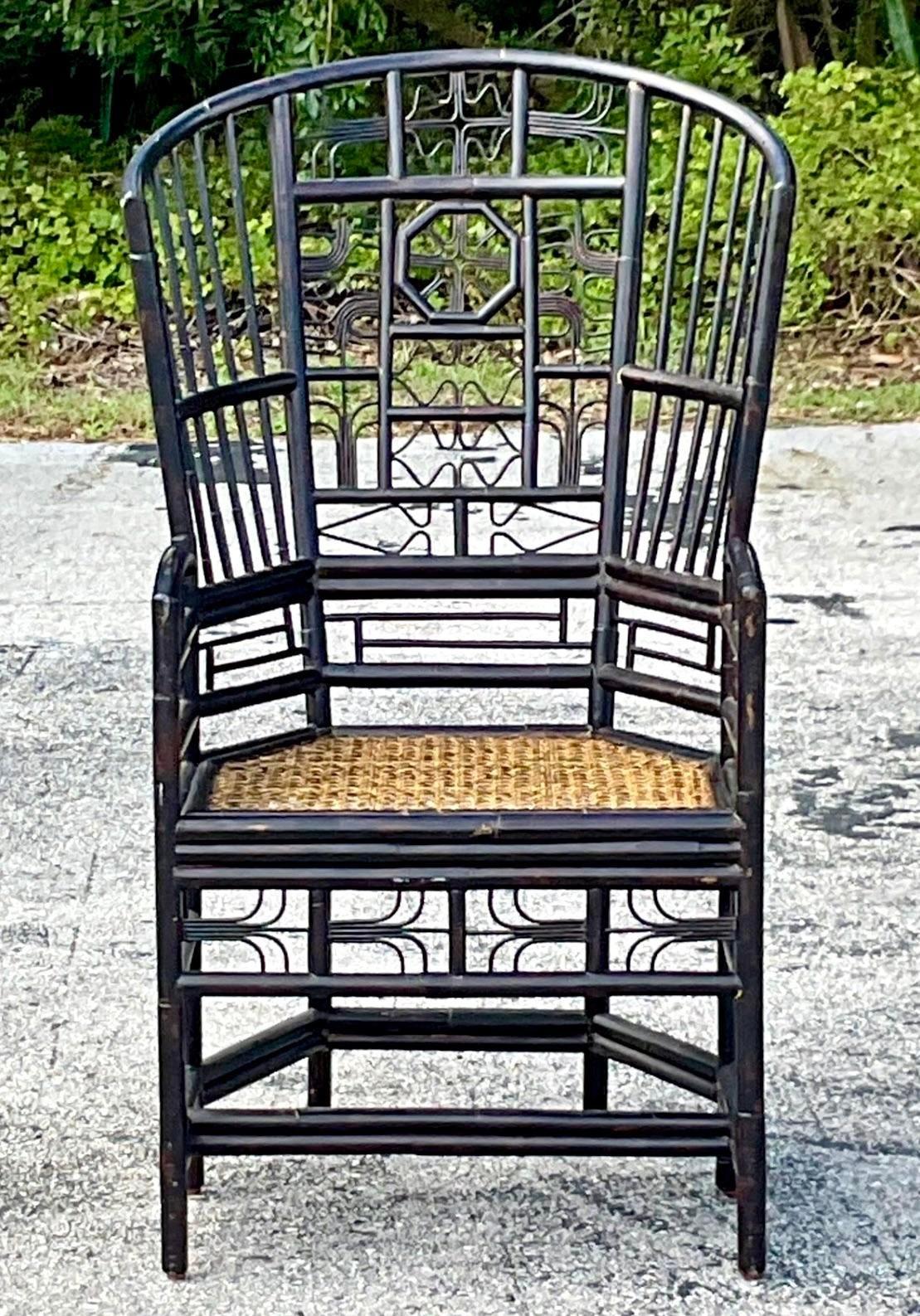 A fantastic vintage Coastal Hugh back lounge chair. A chic ebony rattan in an updated z Brighton design. Inset cane seat. Acquired from a Palm Beach estate. 