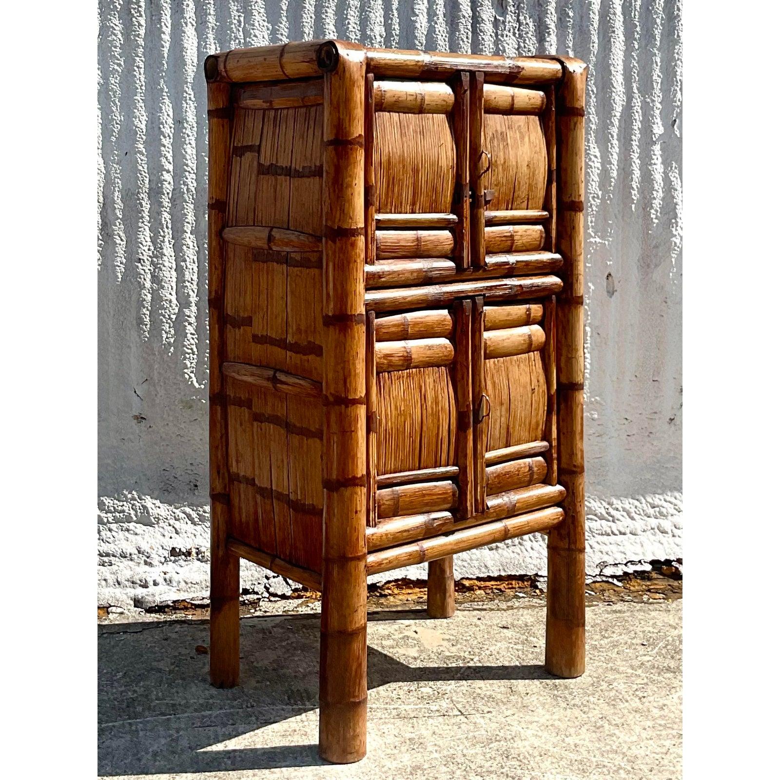 Incredible vintage Coastal armoire. Beautiful elephant bamboo frame with a simple design. Interior slat shelves with a sliding wood latch on the top cabinets. Perfect as an armoire, but also great by the pool for towel storage. Or even a chic Tiki